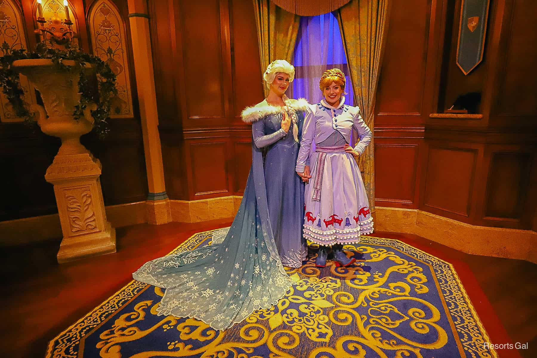 Elsa and Anna pose for a photo wearing their holiday costumes during Mickey's Very Merry Christmas Party. 