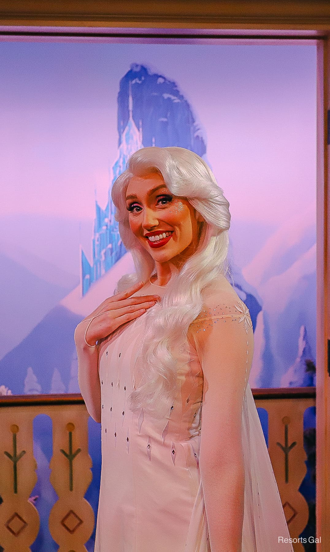 Elsa smiles for a photo wearing her white gown from Frozen 2. 