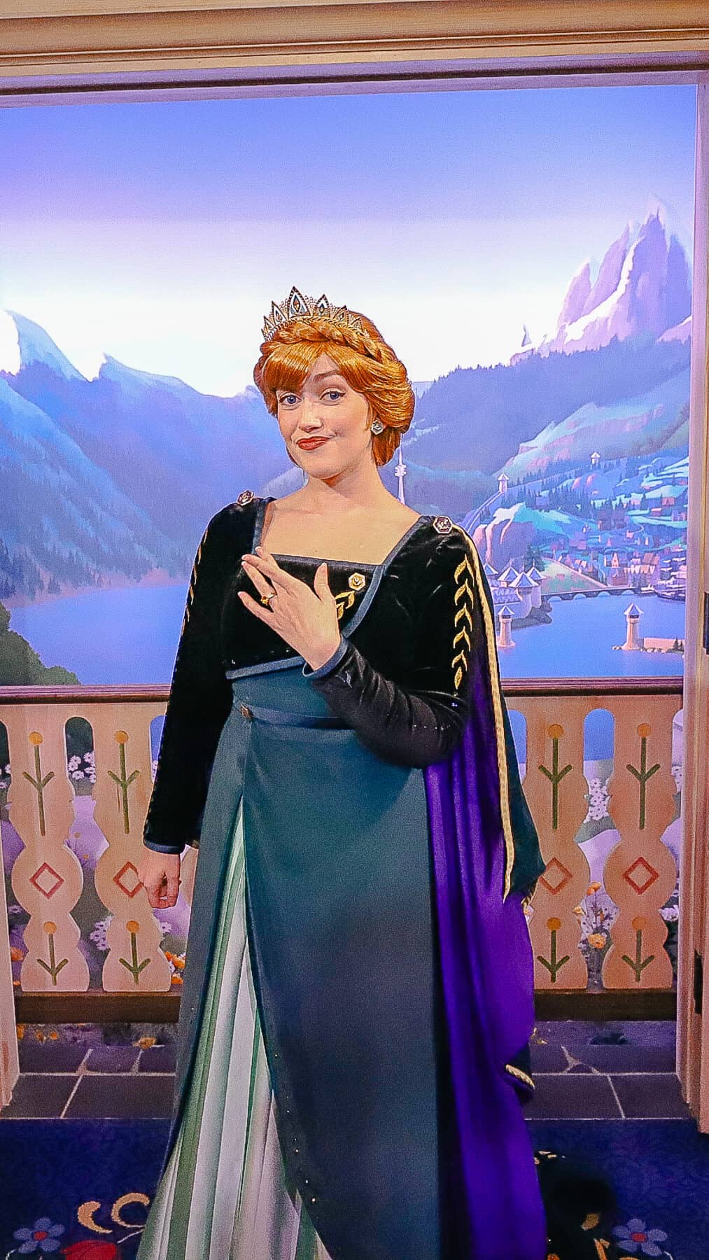 Anna poses with her fingers crossed wearing her queen costume. 