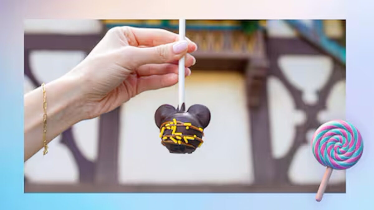 a hand holding a Mickey Chocolate Cake Pop with yellow sprinkles 