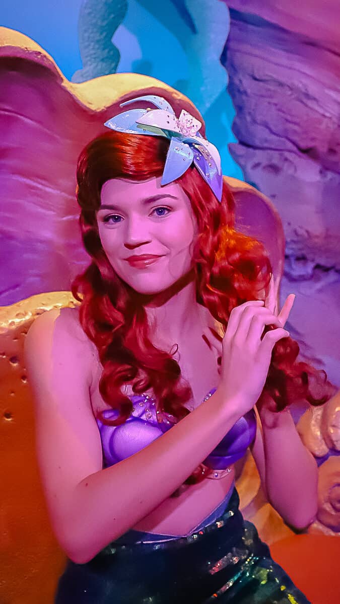 Ariel is fidgeting with her hair as she poses for a photo. 