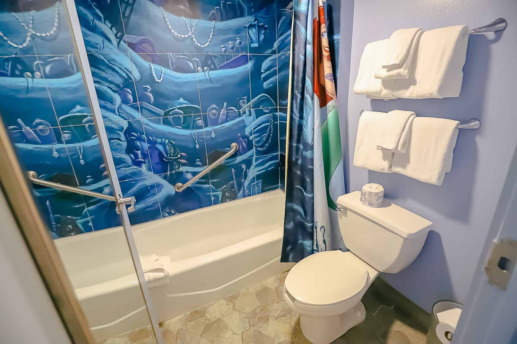 the interior of the tub with shower is painted to look like Ariel's treasure trove 