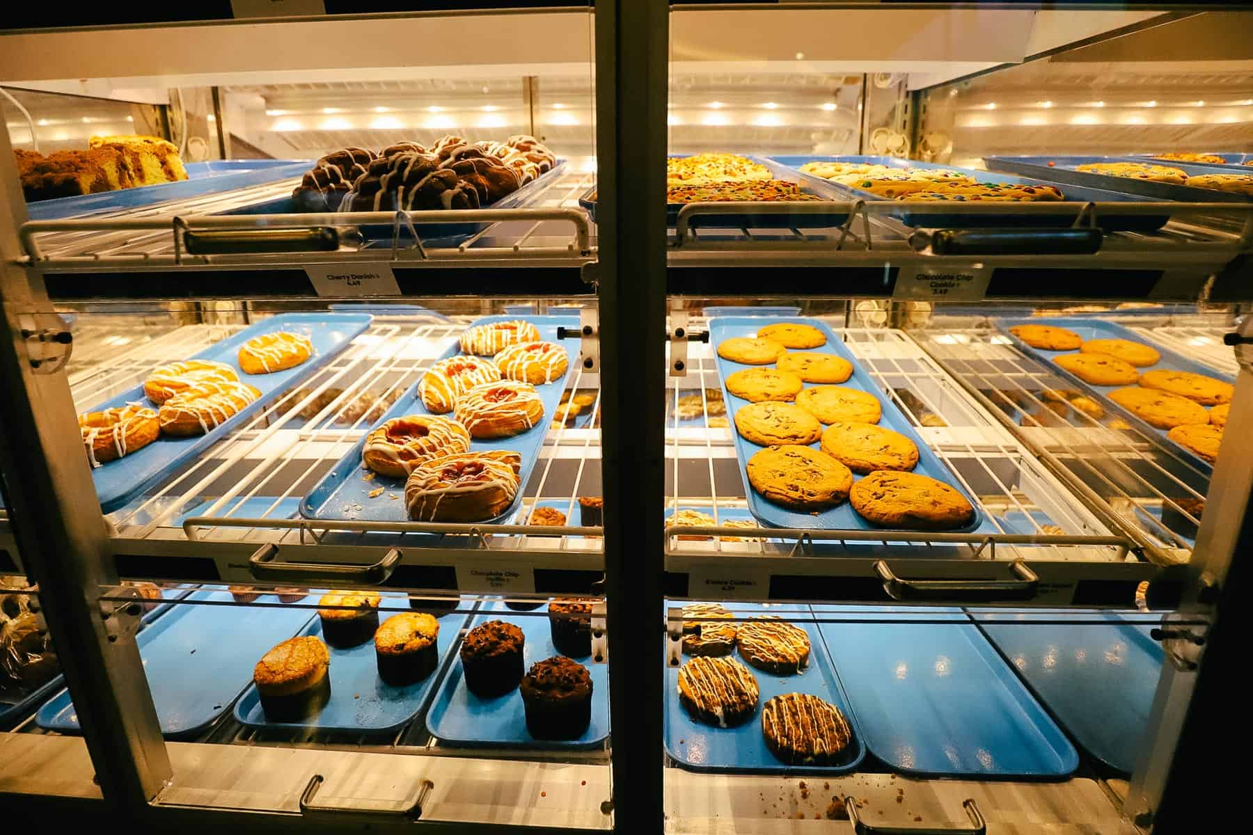 a pastry case with cookies, donuts, and cinnamon rolls 