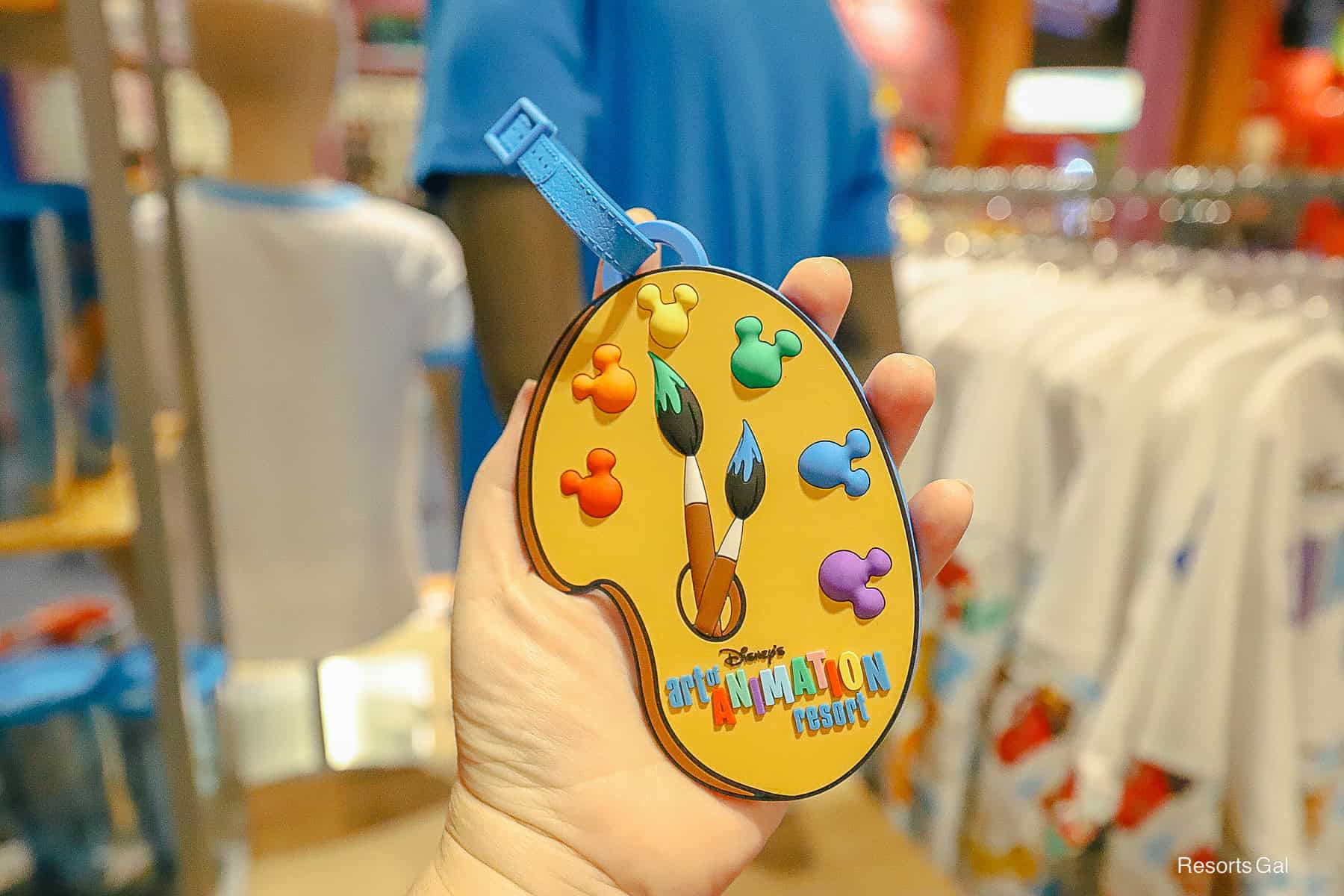 this luggage tag features the resort logo on a palette of paint 