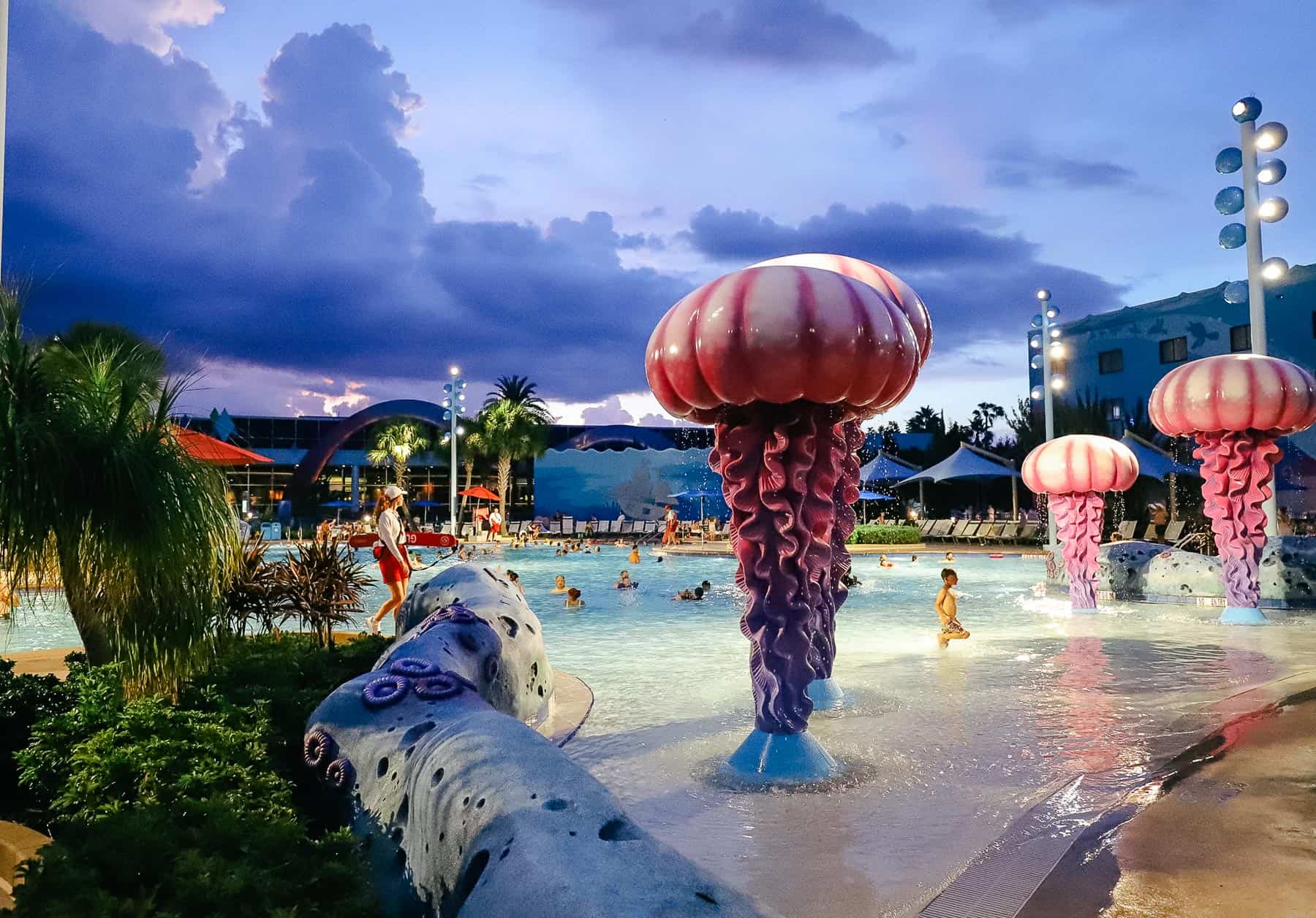 giant jellyfish surrounding the zero depth entry pool at Art of Animation around sunset with pretty purple sky 