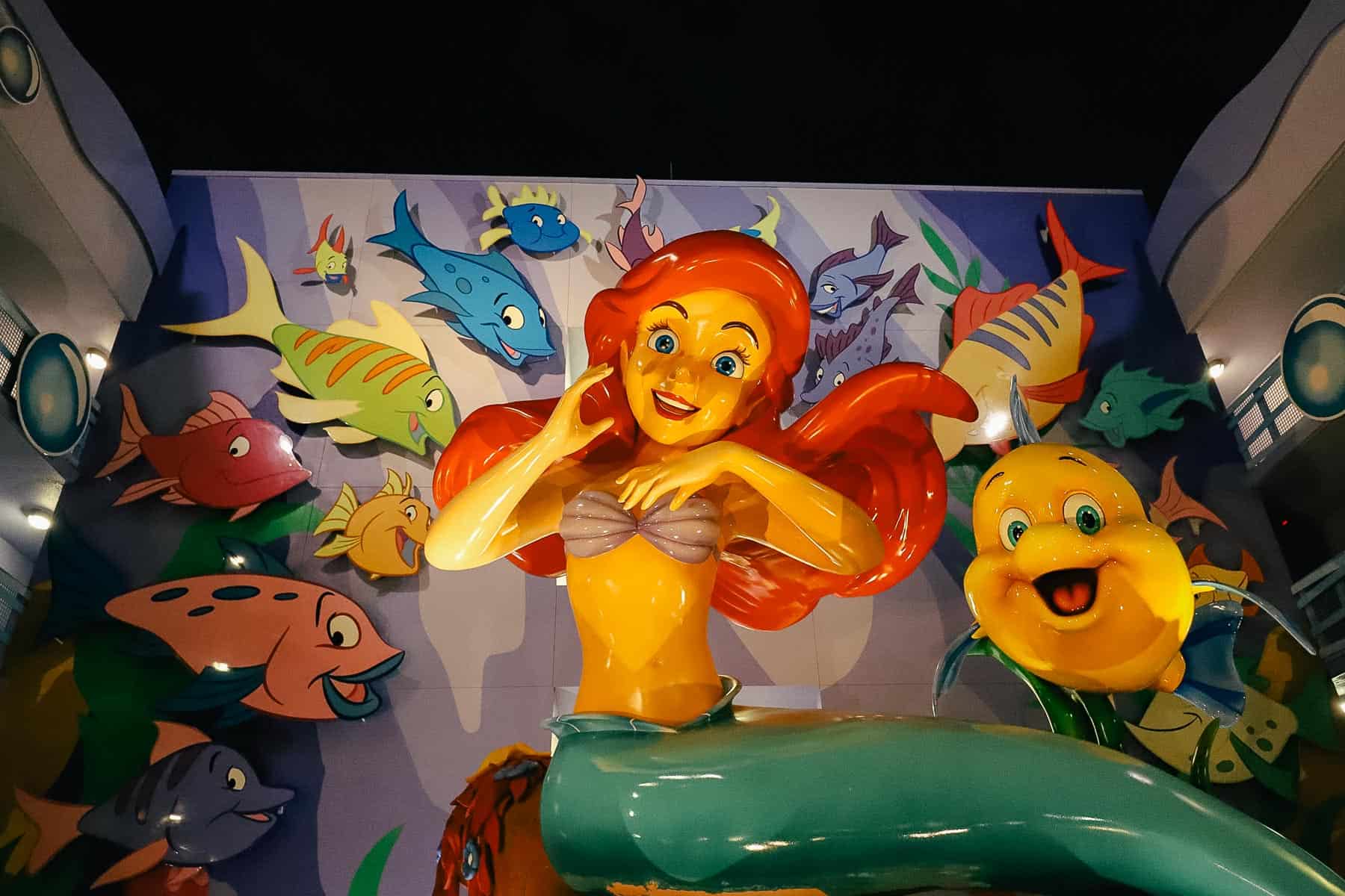 Ariel and Flounder sit outside building eight at Disney's Art of Animation. 