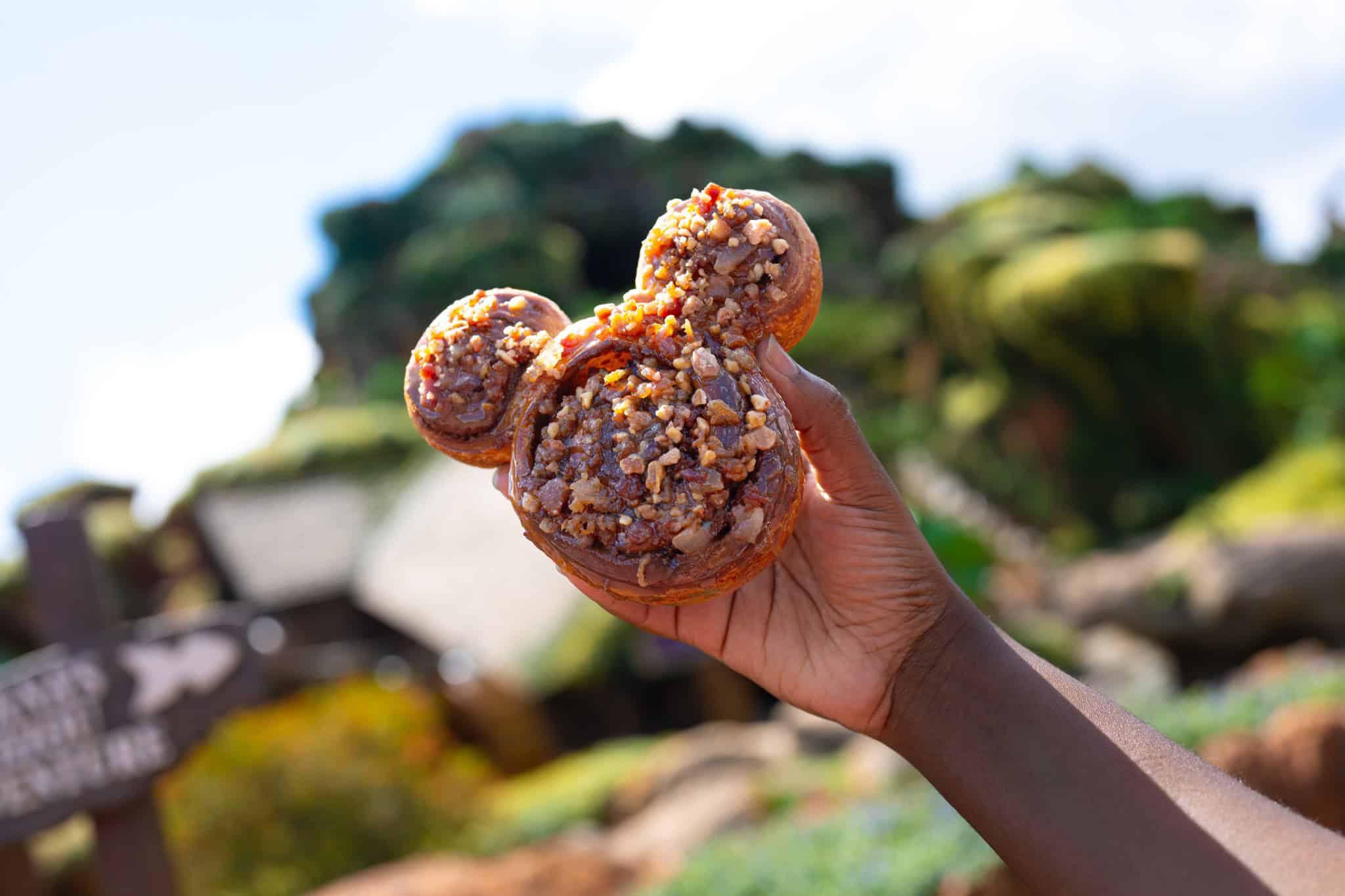 a Mickey-shaped cinnamon roll with pecans, bacon, and caramel