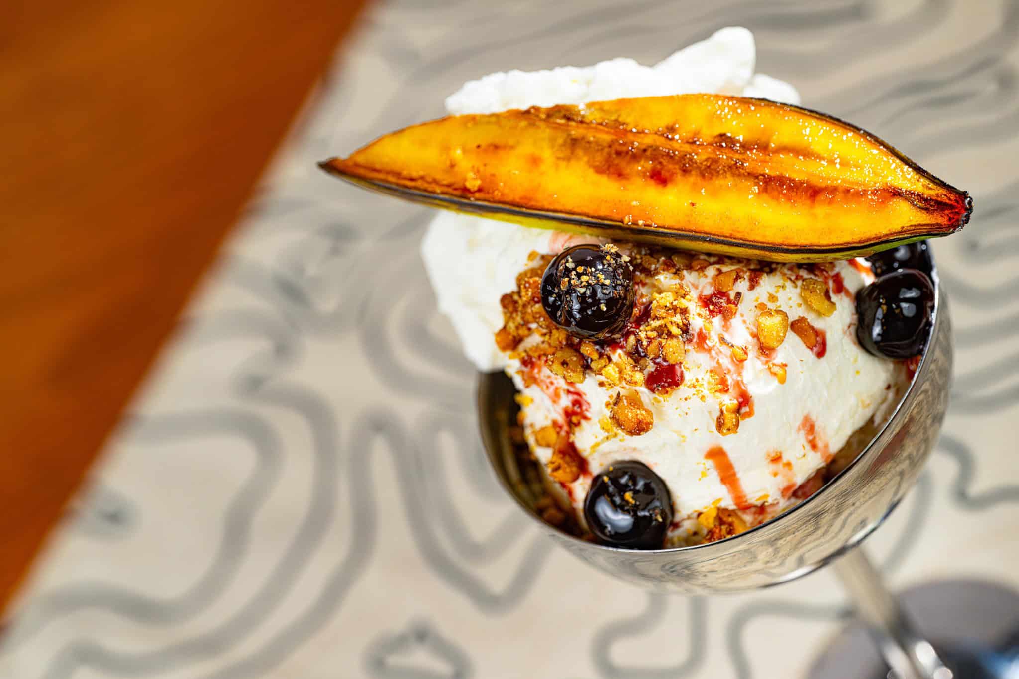 a roasted banana on top of a formal split frozen dessert