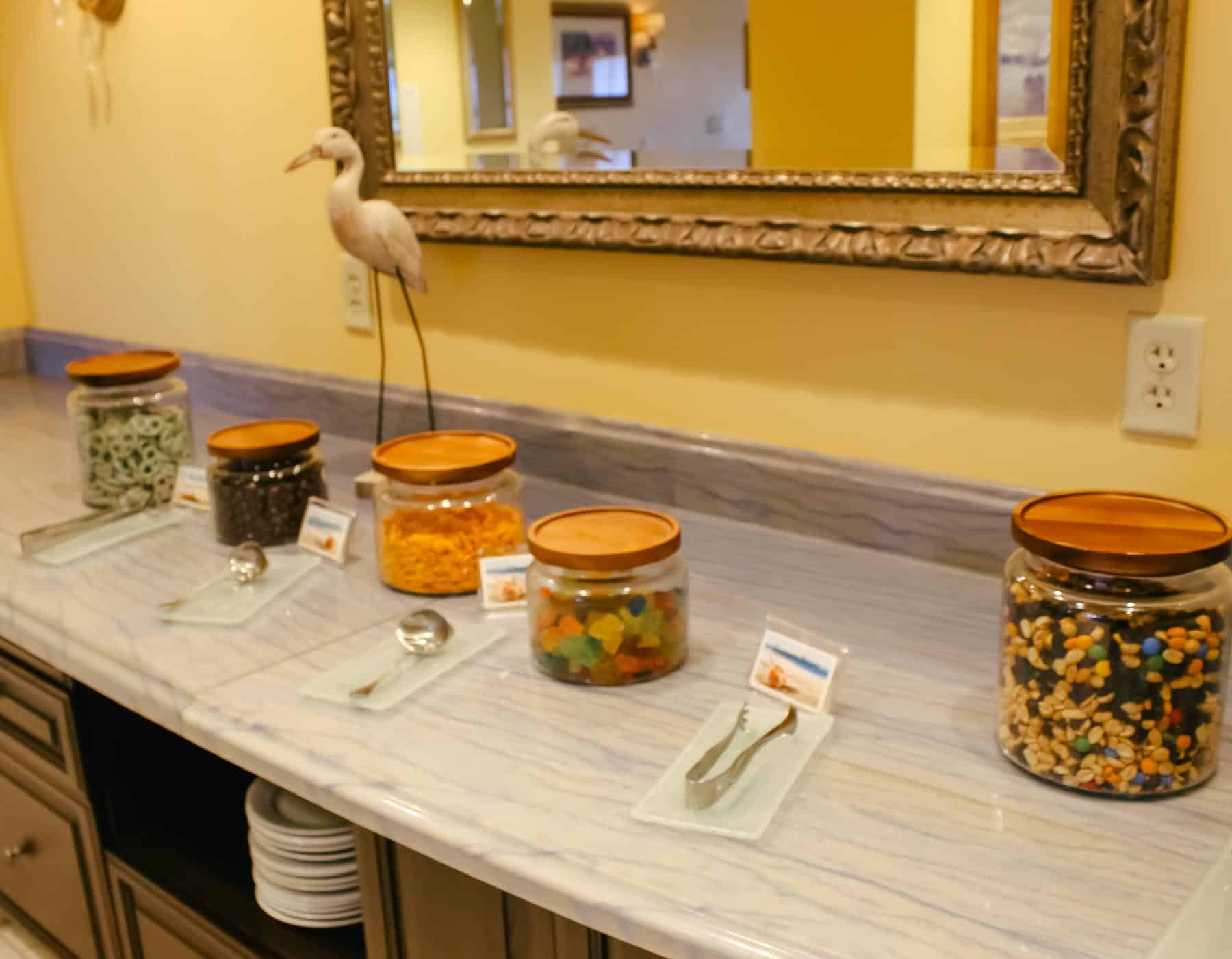 Various jars of snack mixes with yogurt pretzels, espresso beans, goldfish, gummies, and trail mix 