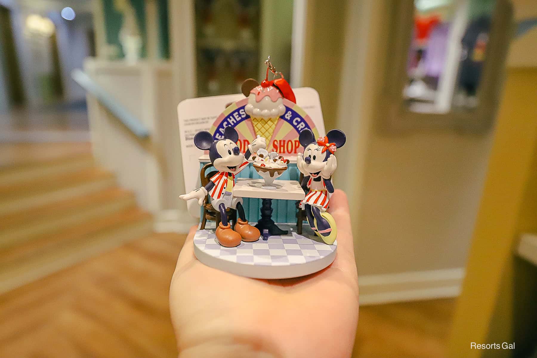 a figurine ornament with Mickey and Minnie Mouse enjoying the kitchen sink sundae at Beaches and Cream