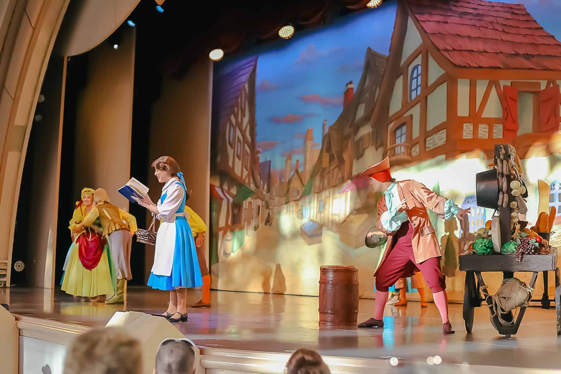 Belle in her village dress reading a book. 