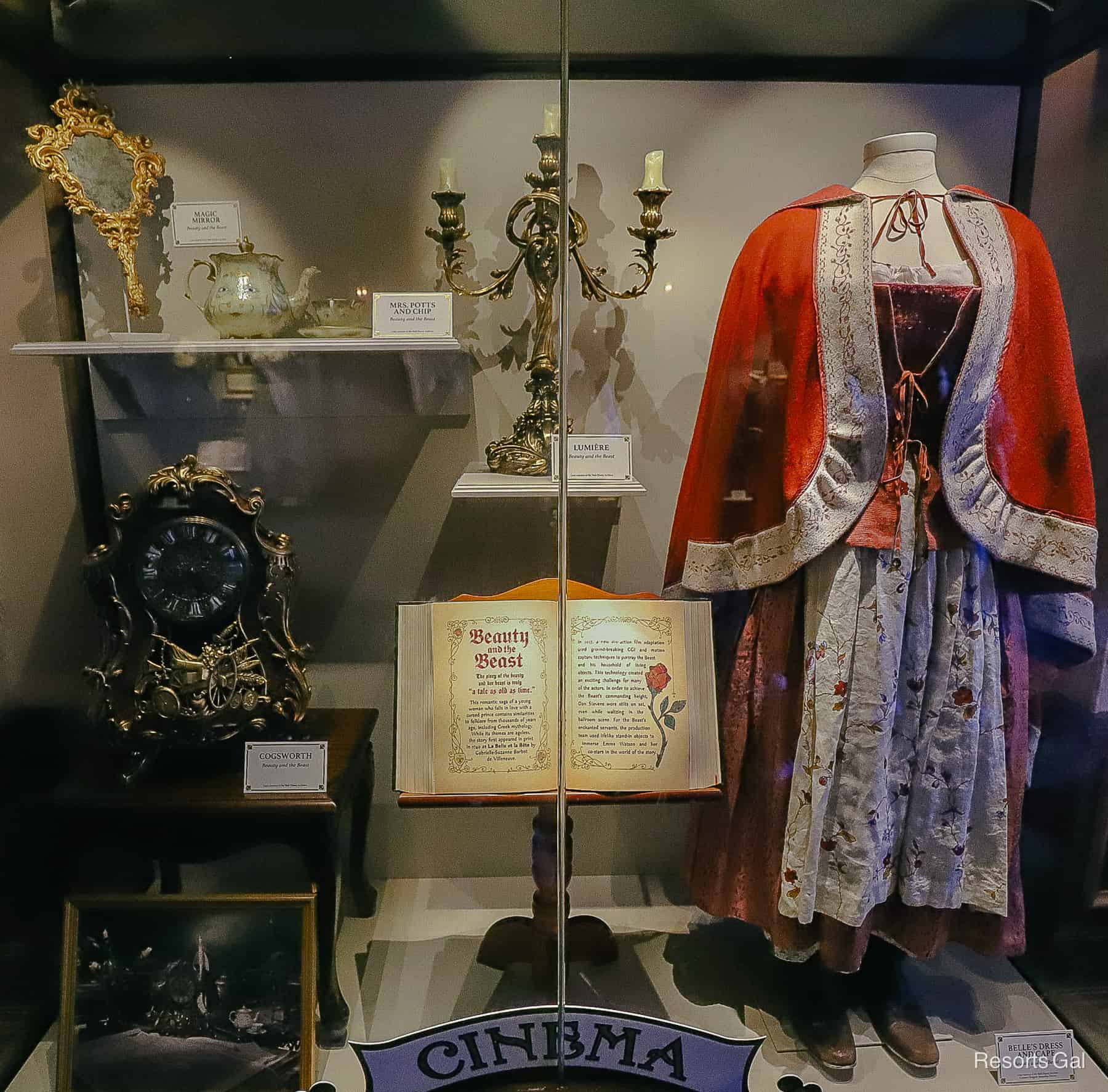 display case with a dress, the mirror, and other items from the live-action film
