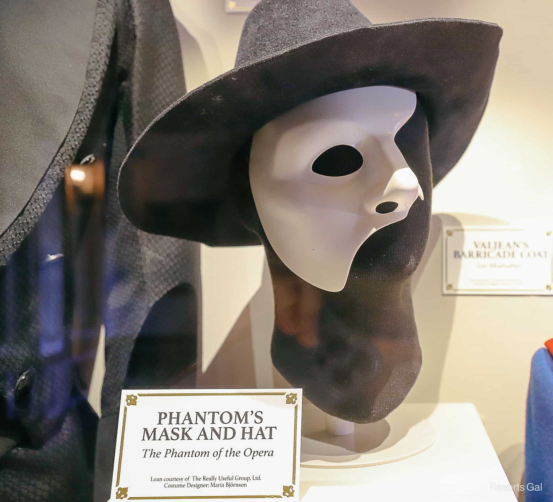 a black hat with a white face mask worn in Phantom of the Opera 