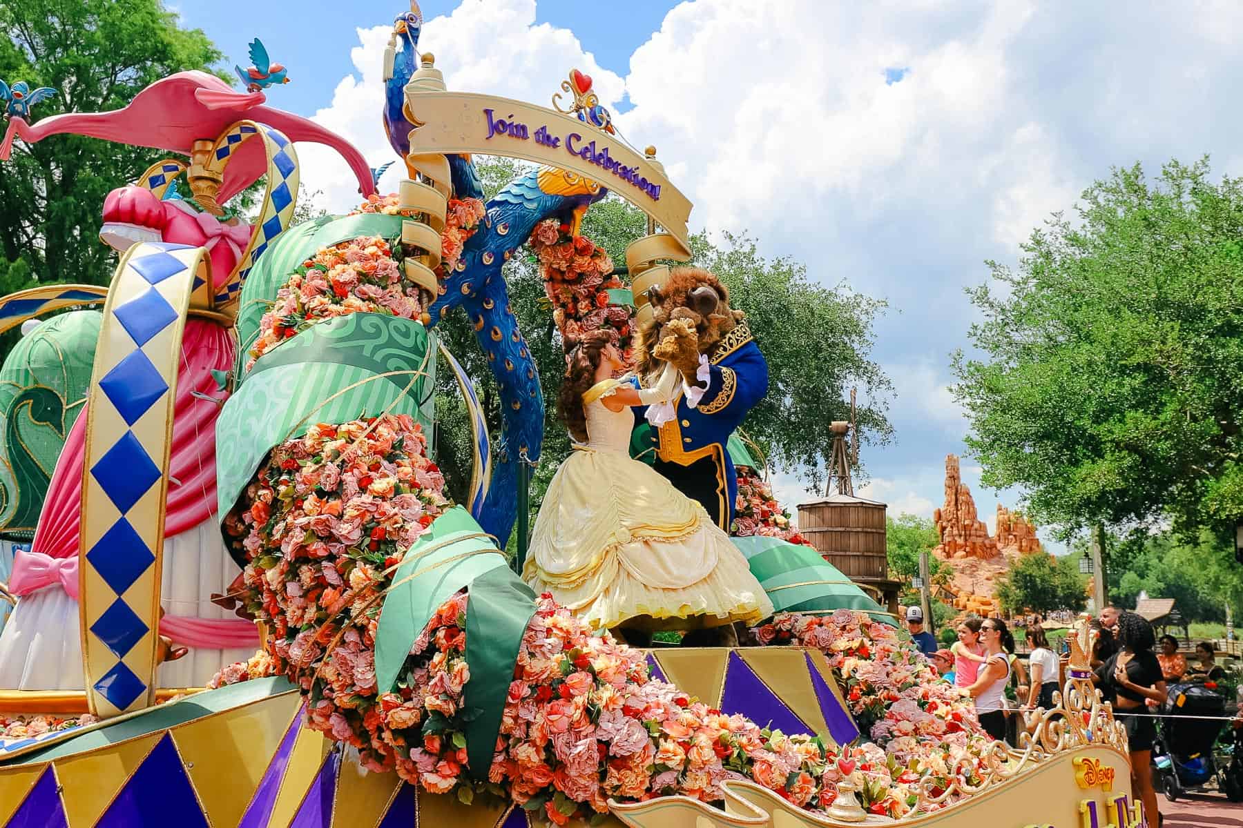 Belle dancing with Beast on a float in the parade at Magic Kingdom. 