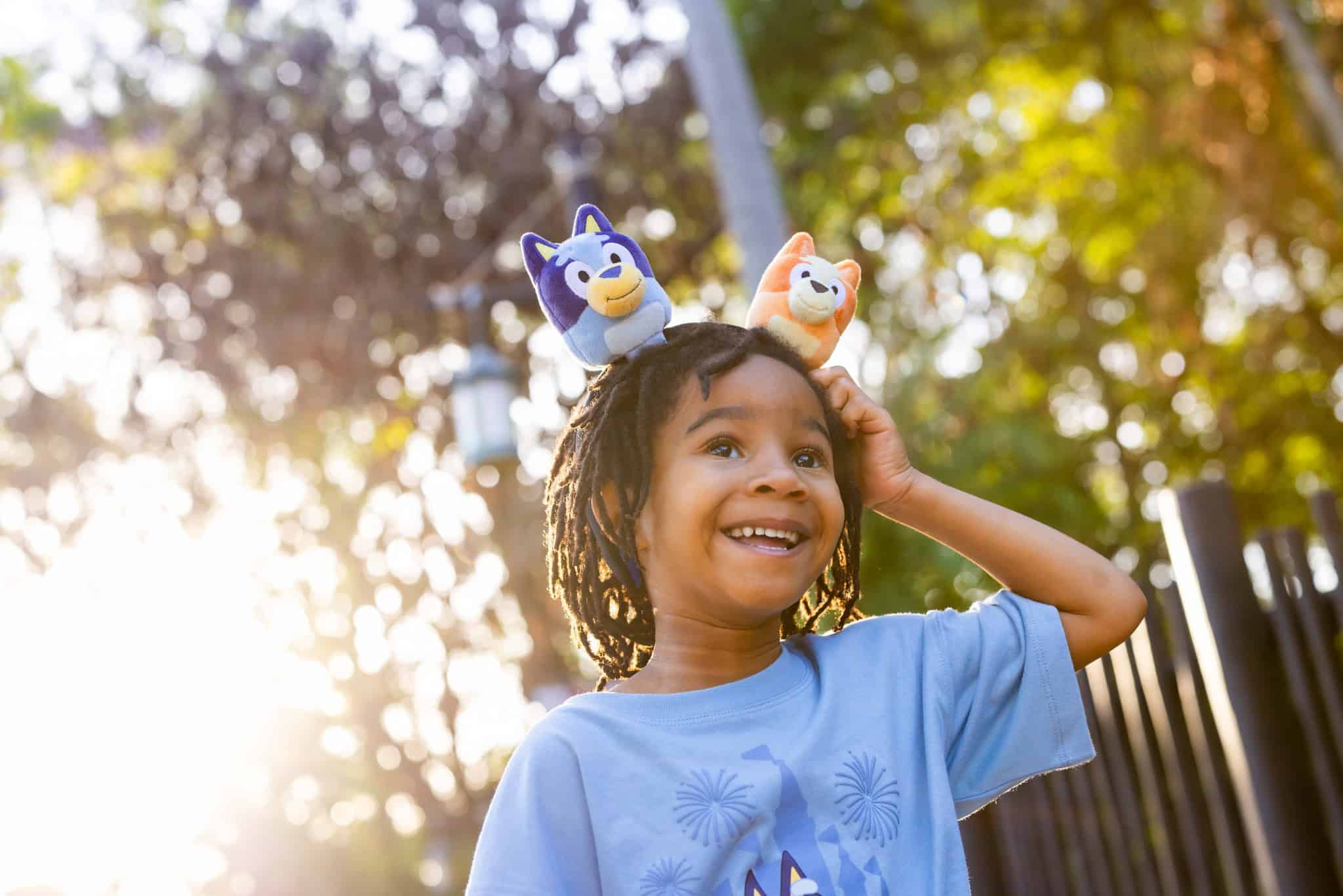 a child wearing a Create Your Own Bluey and Bingo plush headband 
