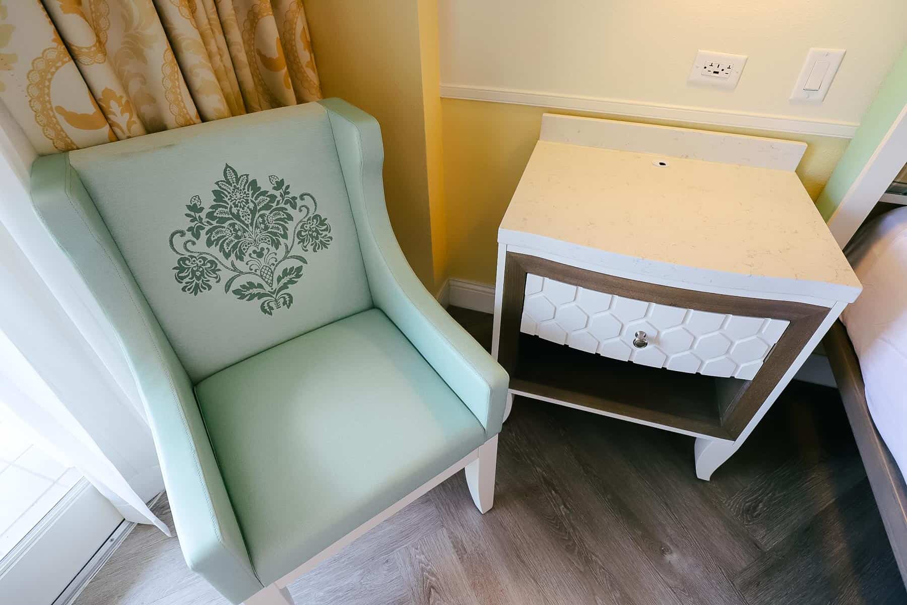 A reading chair and a side table in a guest room at Disney's Boardwalk. 
