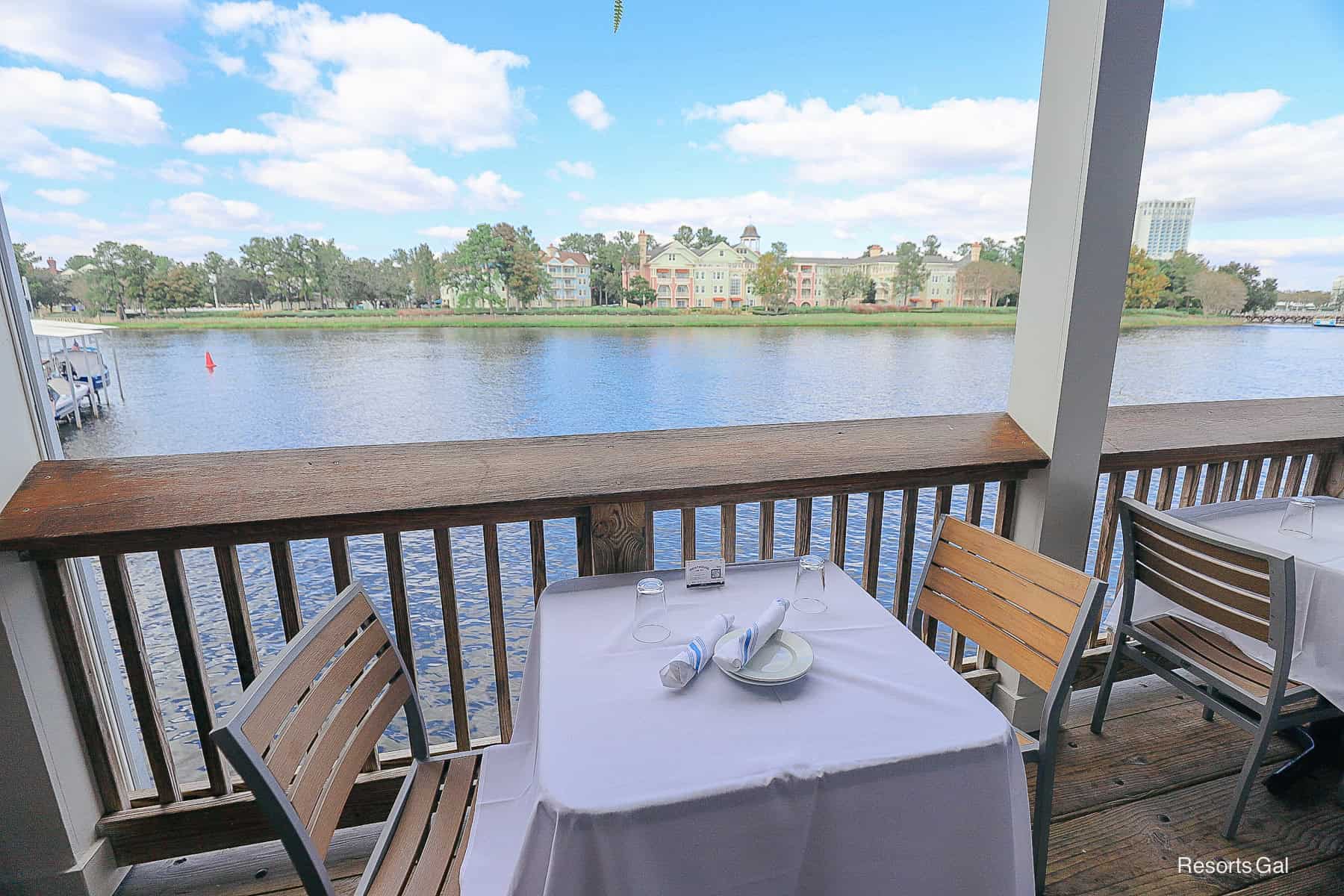 a table and chairs facing the water and Saratoga Springs in the distance 