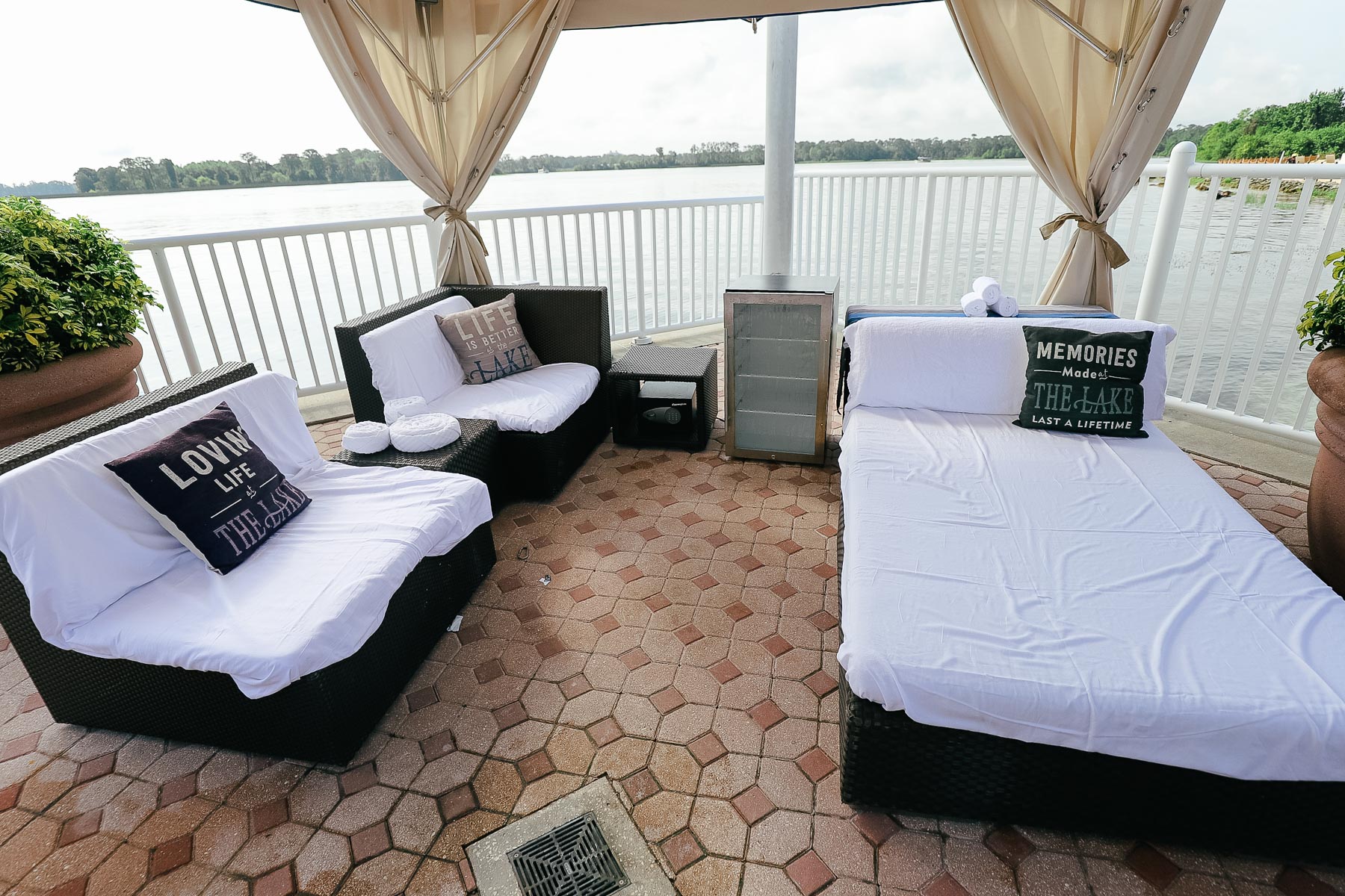 a chaise lounge and two chairs with a mini refrigerator sitting under the canopy of a cabana at Disney's Contemporary 