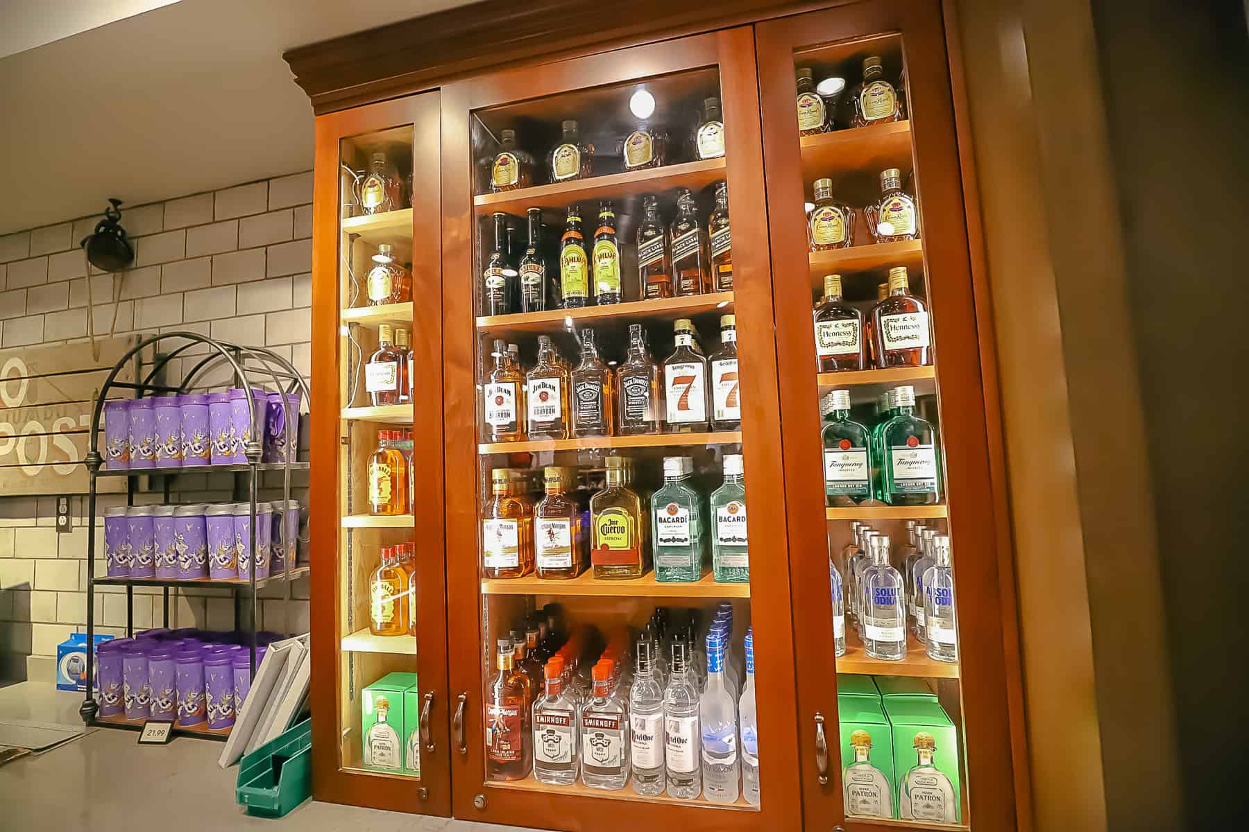 a case behind the register that displays various bottles of liquor at Disney's Caribbean Beach Resort 