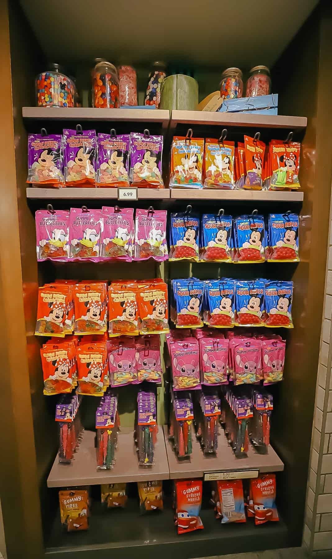 a display with Disney branded candy includes sour balls, gummi butterflies and gummi worms 