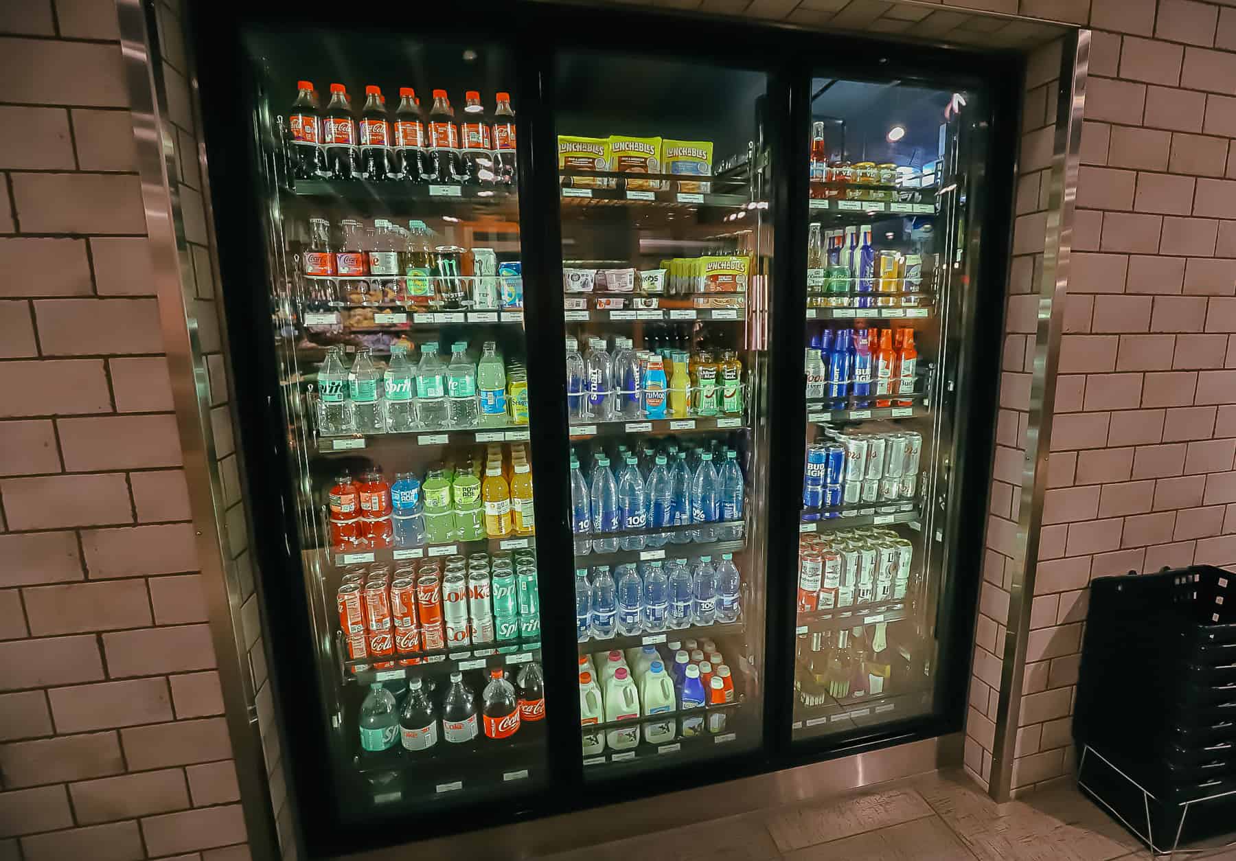 a refrigerated case with bottled drinks, soda, water, beer, and cartons of milk at Calypso Trading Post 