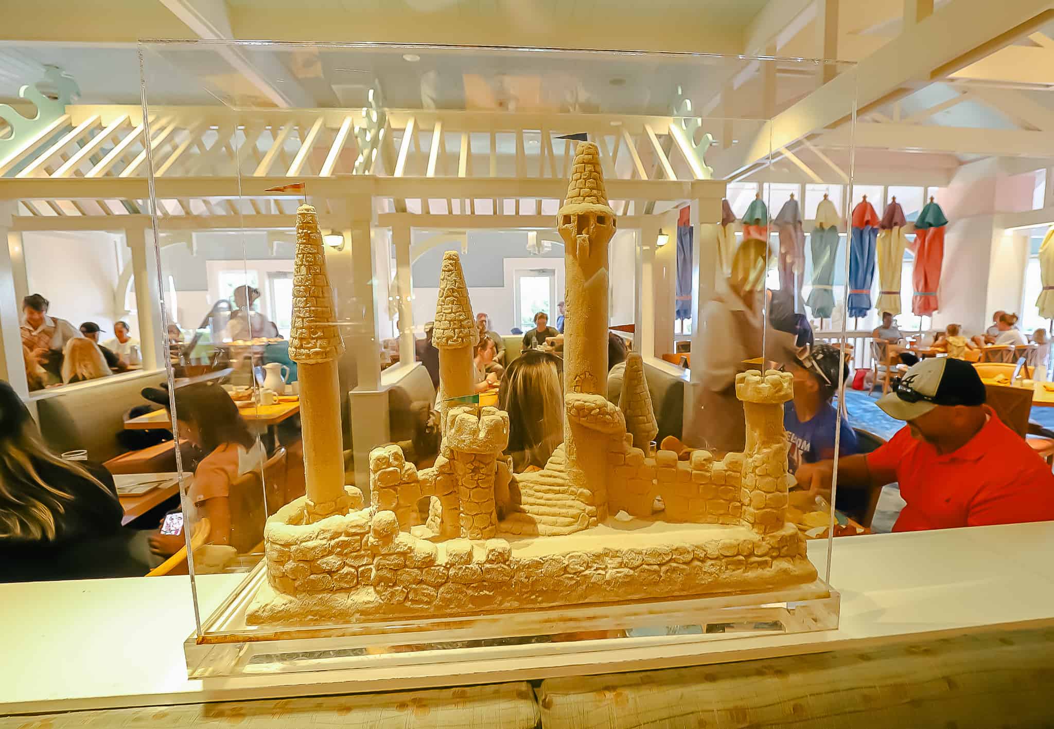 A sand castle inside a glass display cast is part of the beach theming at Cape May Cafe. 