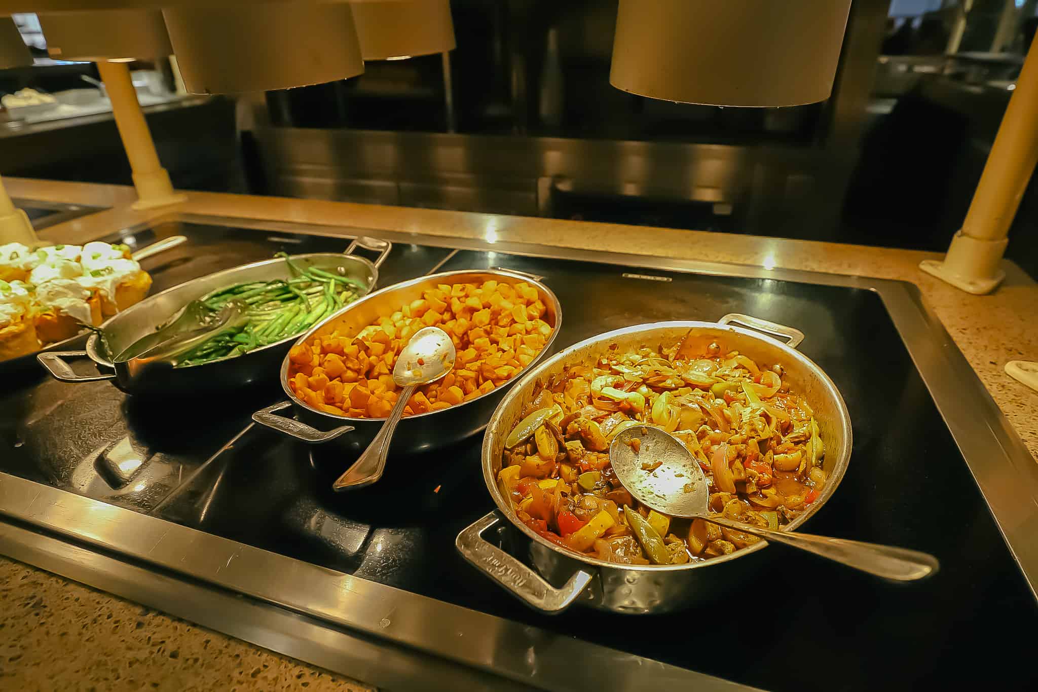 Plant based items on the buffet include asparagus and a tofu vegetable dish. 