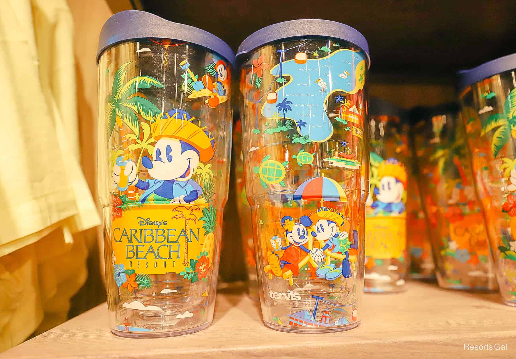 a tumbler with various resort scenes and the Caribbean Beach logo 