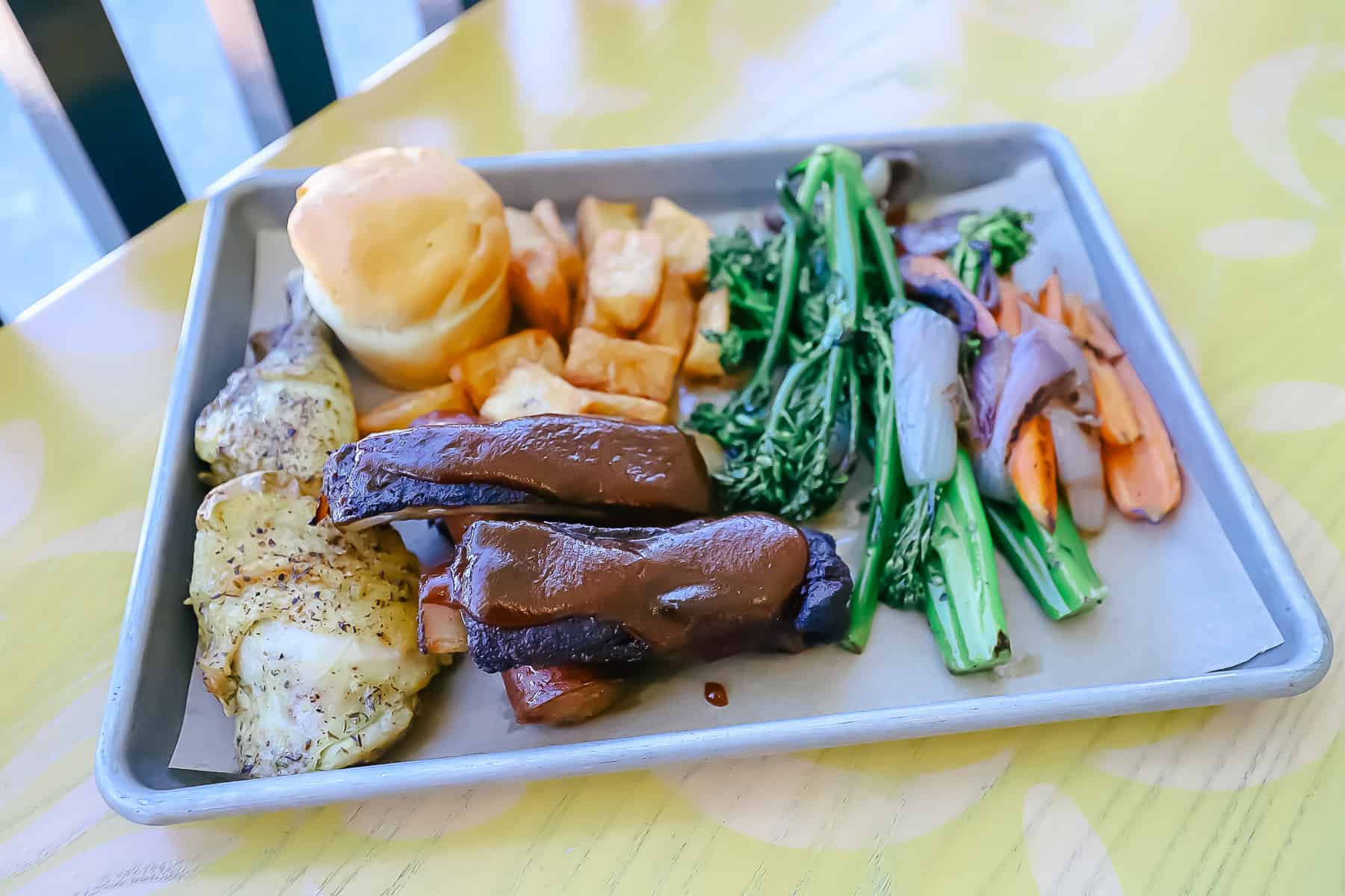 a platter of food with ribs and chicken from Caribbean Beach's quick service