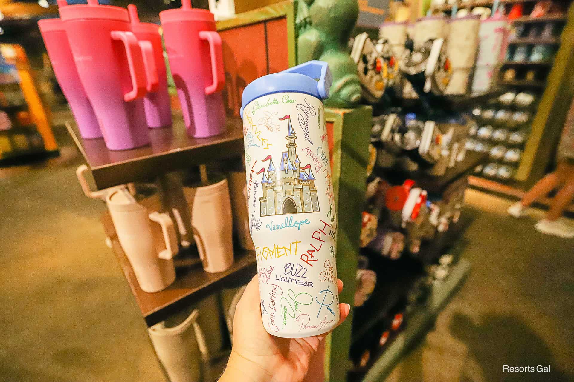 the front of the tumbler features Cinderella Castle surrounded by character autographs with a blue top