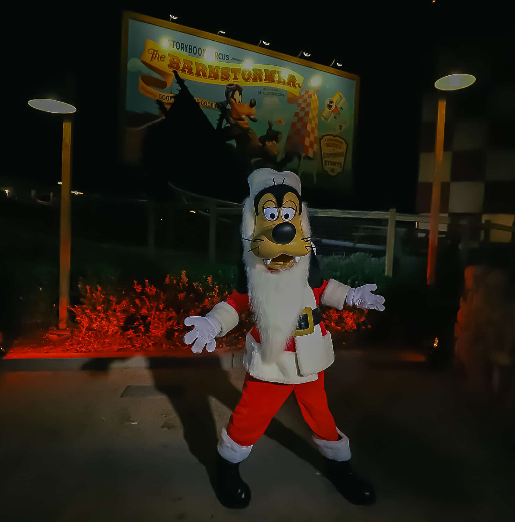 Santa Goofy poses for the camera wearing a fake beard and santa suit. 