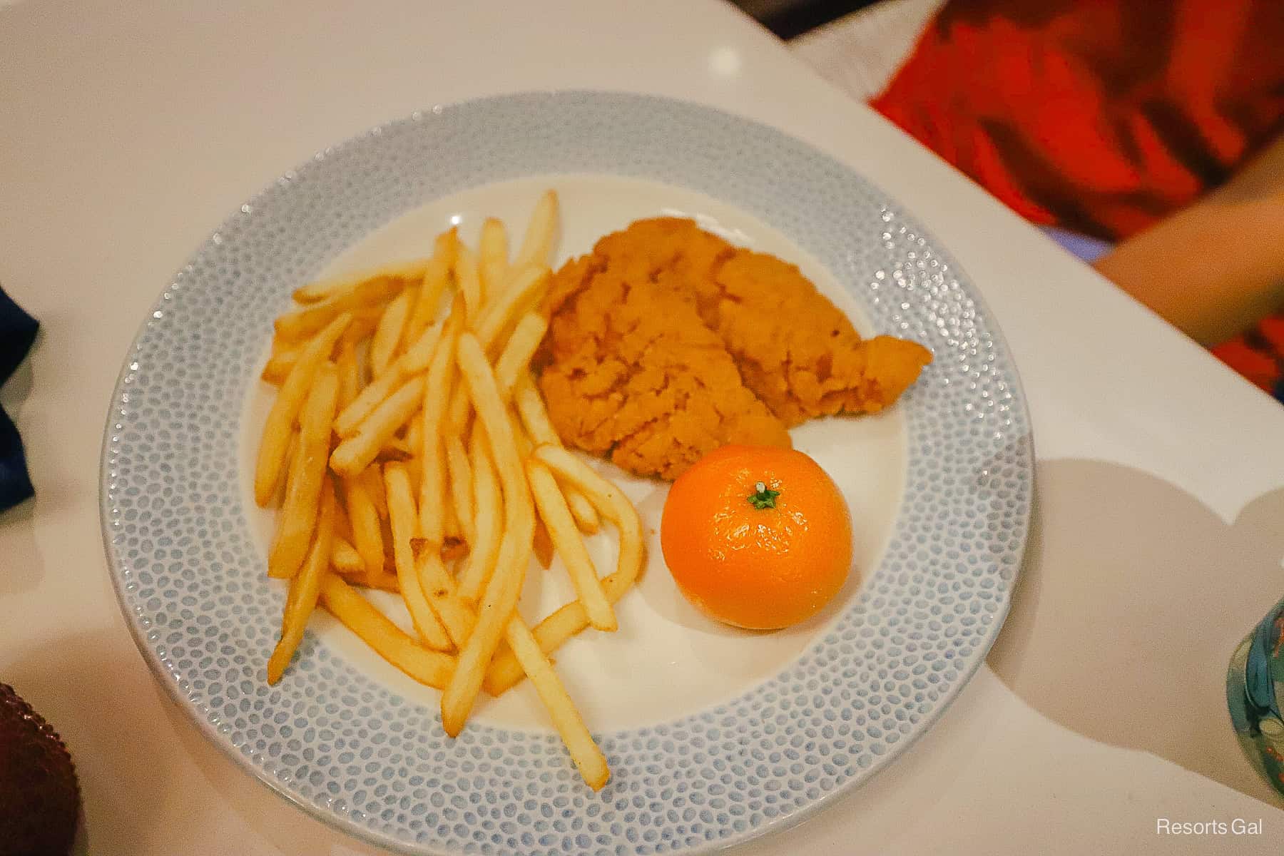 an order of chicken strips with fries and a Mandarin orange