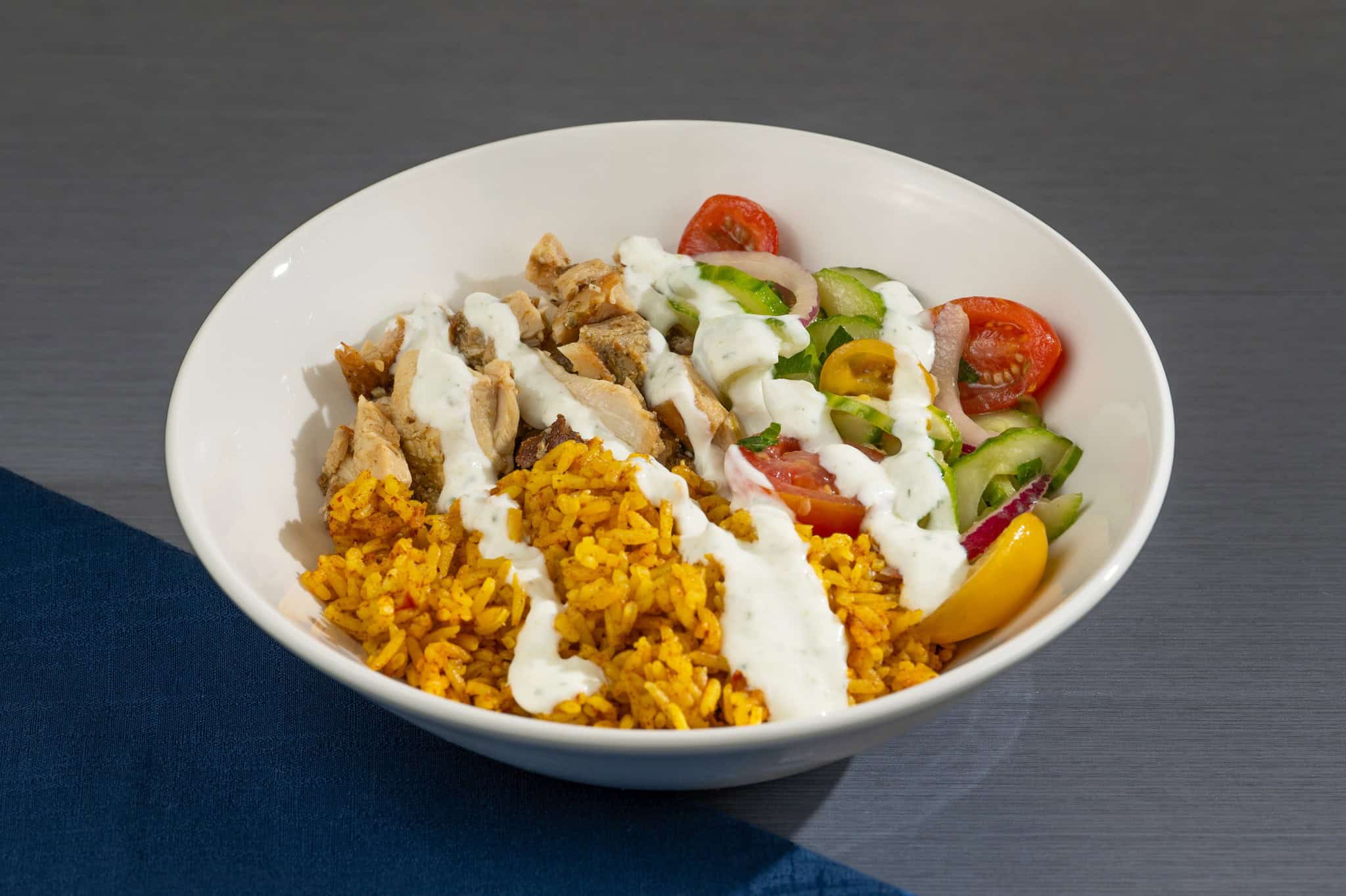 a bowl of rice, chicken, and veggies