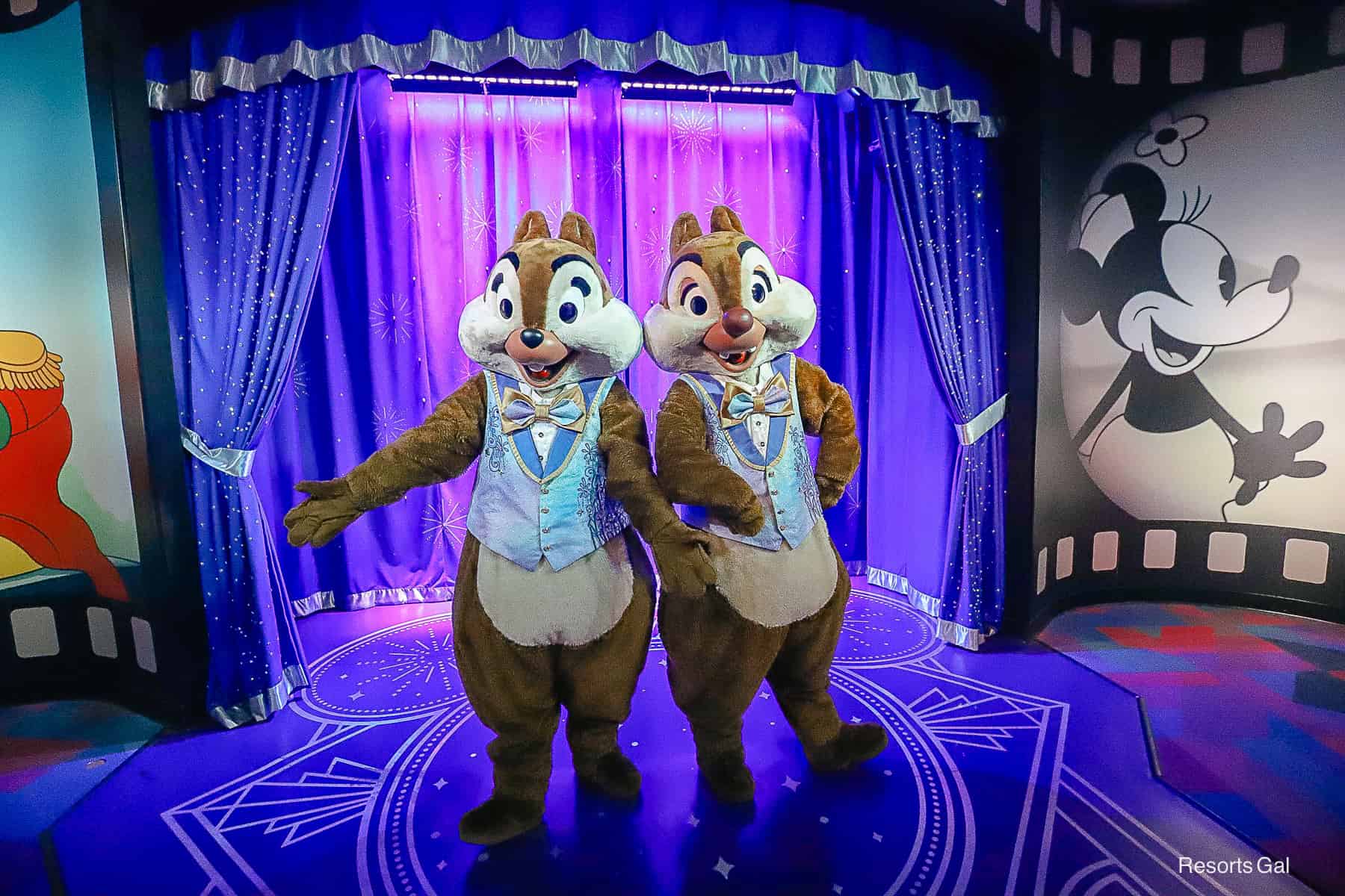 Chip and Dale standing in front of a blue and silver curtain