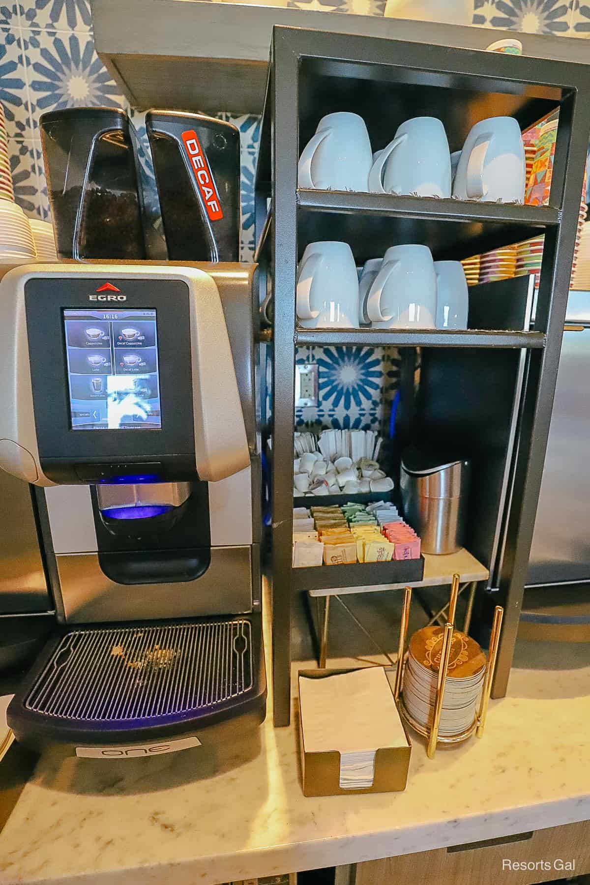 an Egro machine with coffee cups, sweeteners, cream, and napkins 