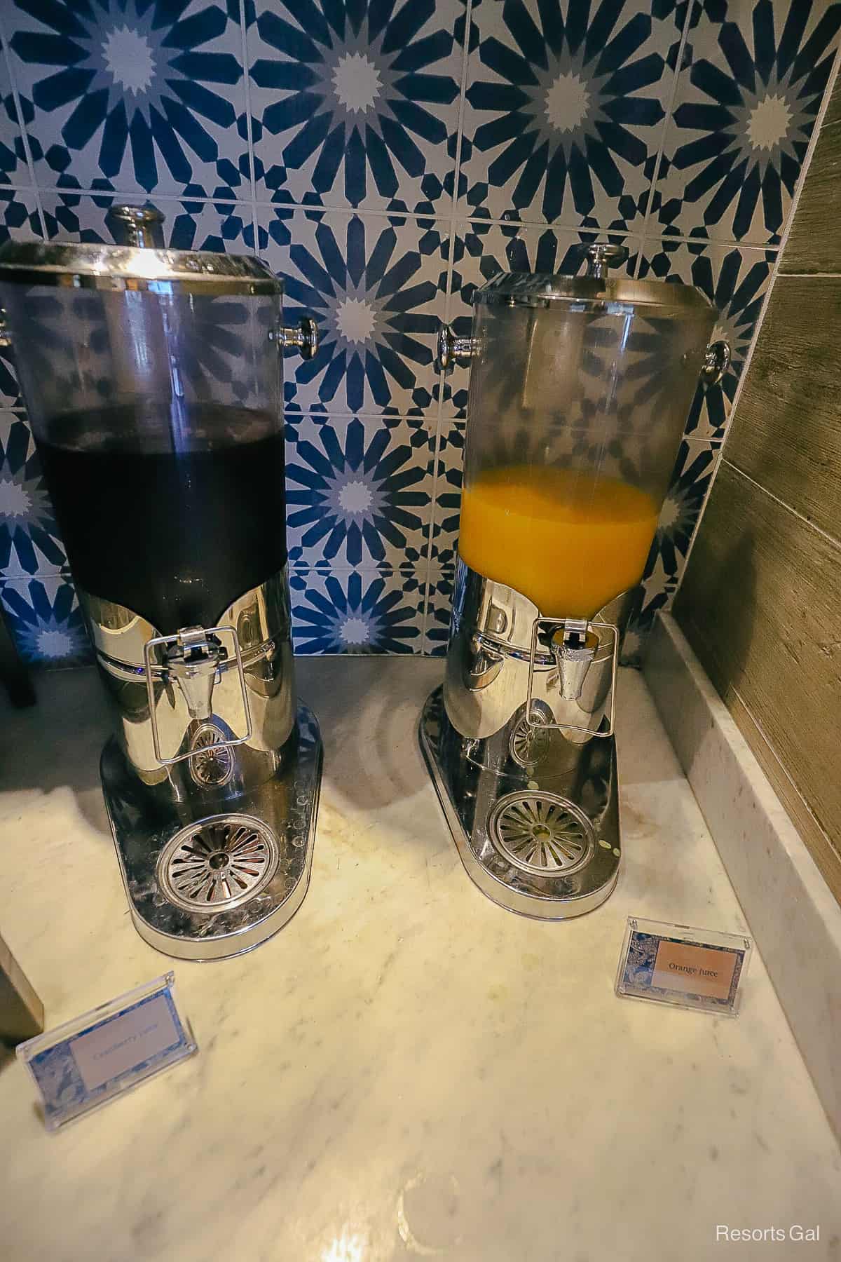 cranberry and orange juices in dispensers 