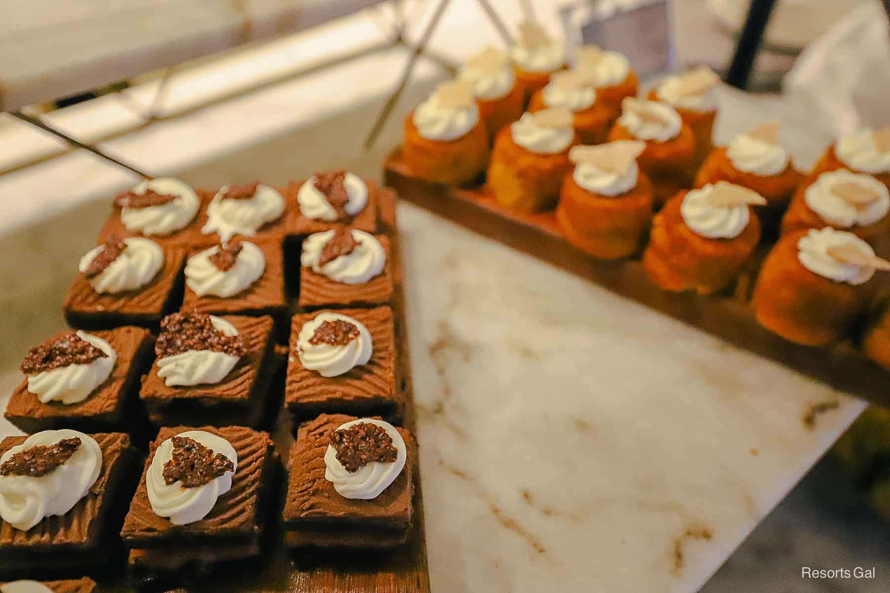 a platter with chocolate cakes and carrot cake in the background 