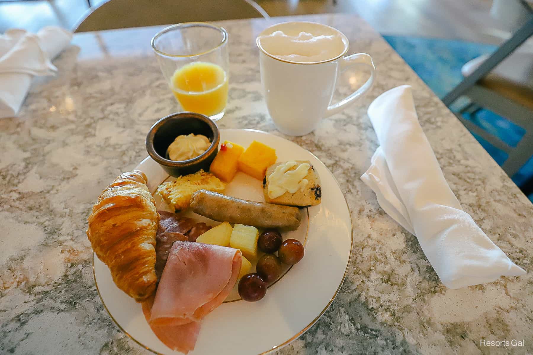 a prepared plate at breakfast with orange juice and a cappuccino 