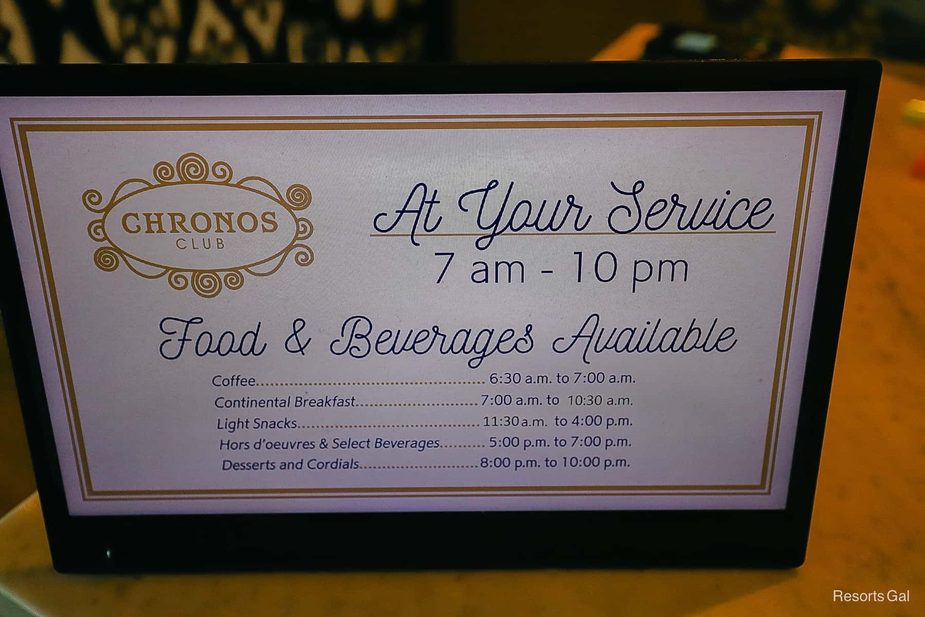 a sign that lists the service hours throughout the day for the Chronos Club. It says the lounge is open from 7:00 a.m. until 10:00 p.m. 