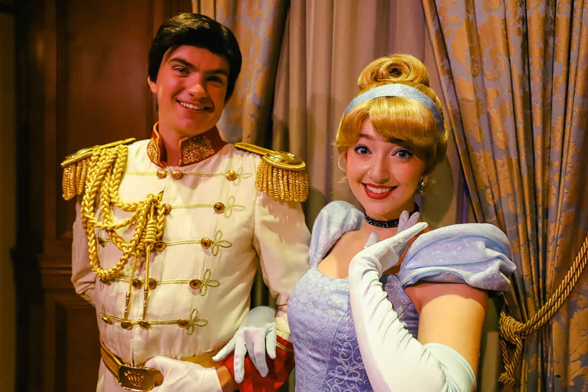 Cinderella and Prince Charming smile for a photo at their character meet. 