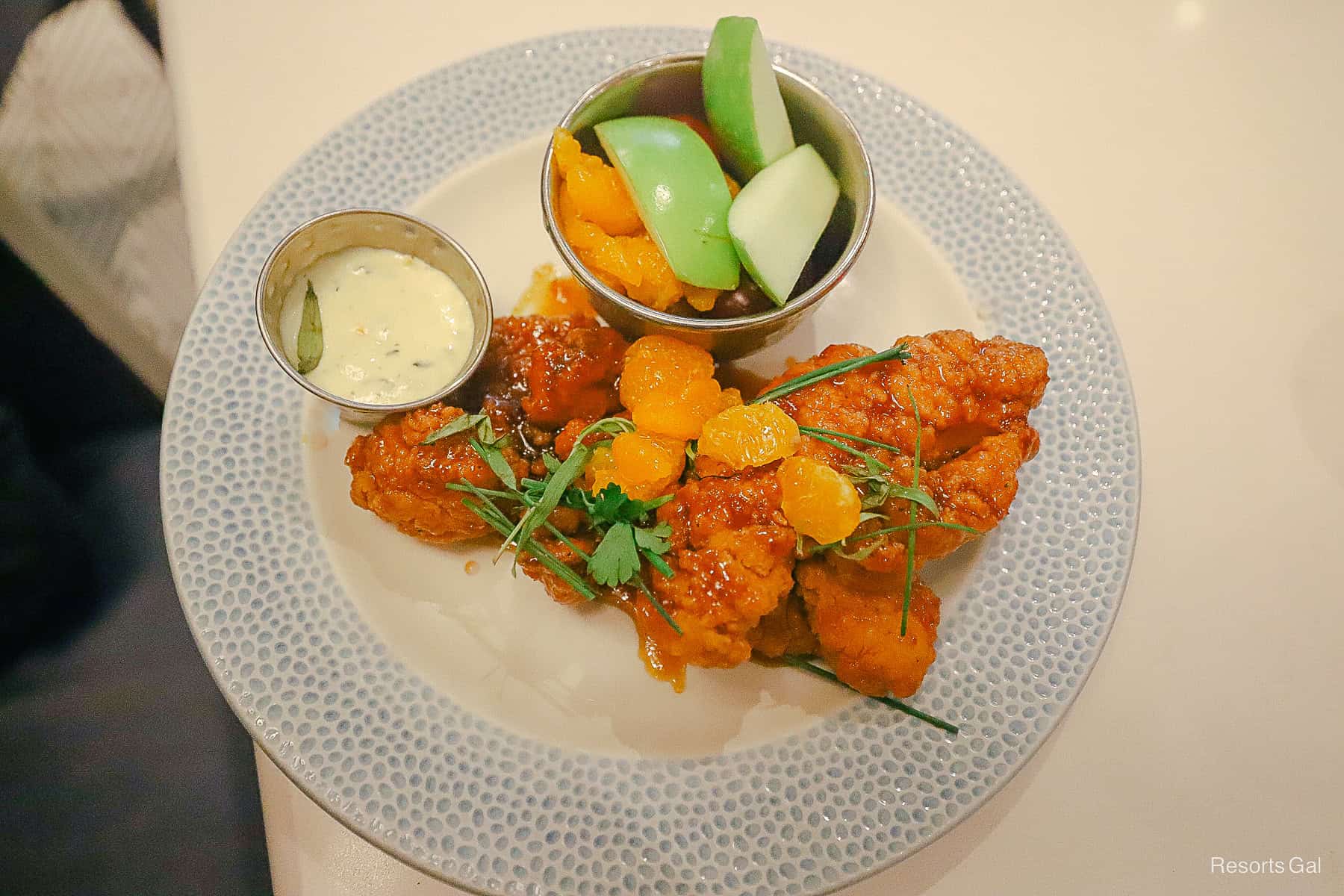 chicken fingers sauced in a citrus glaze with a side of aioli and fruit