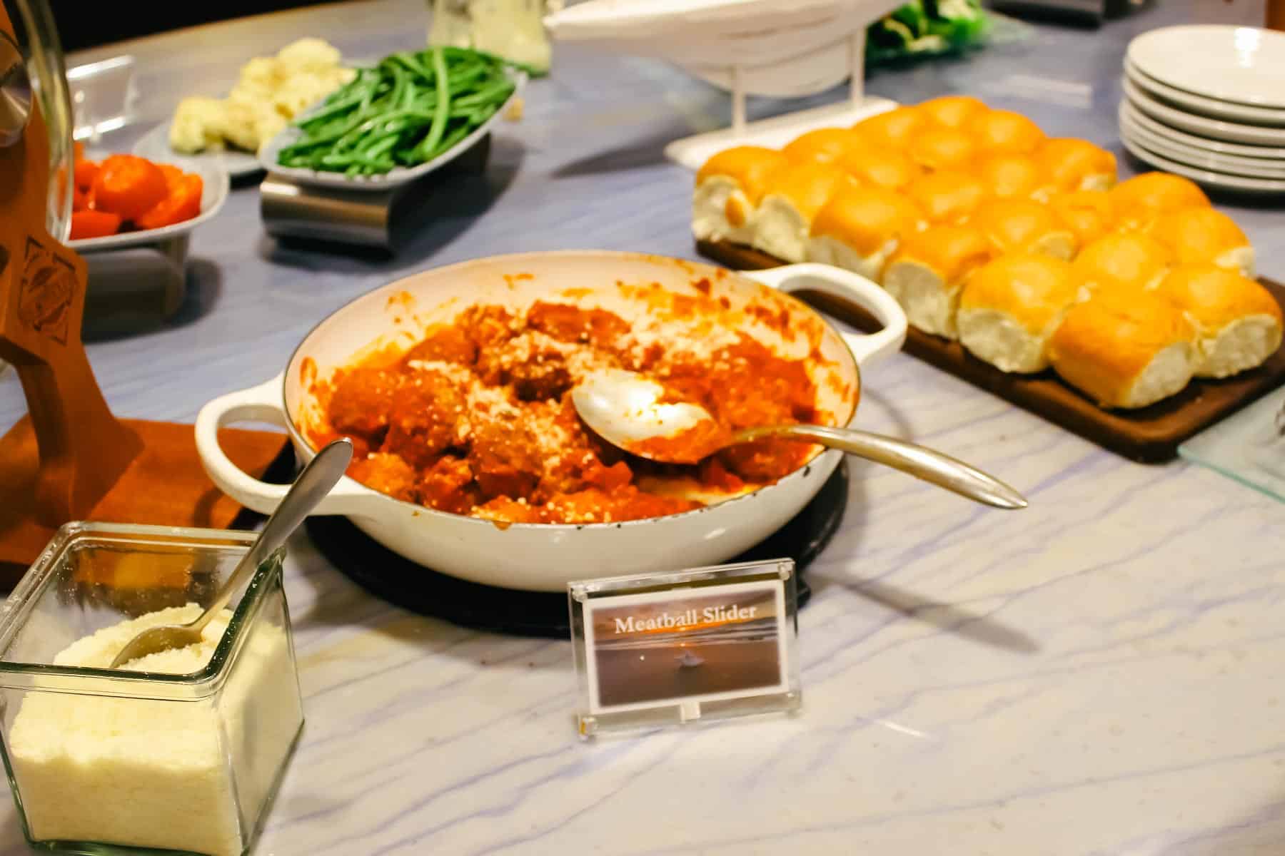 a meatball slider with parmesan cheese and rolls 