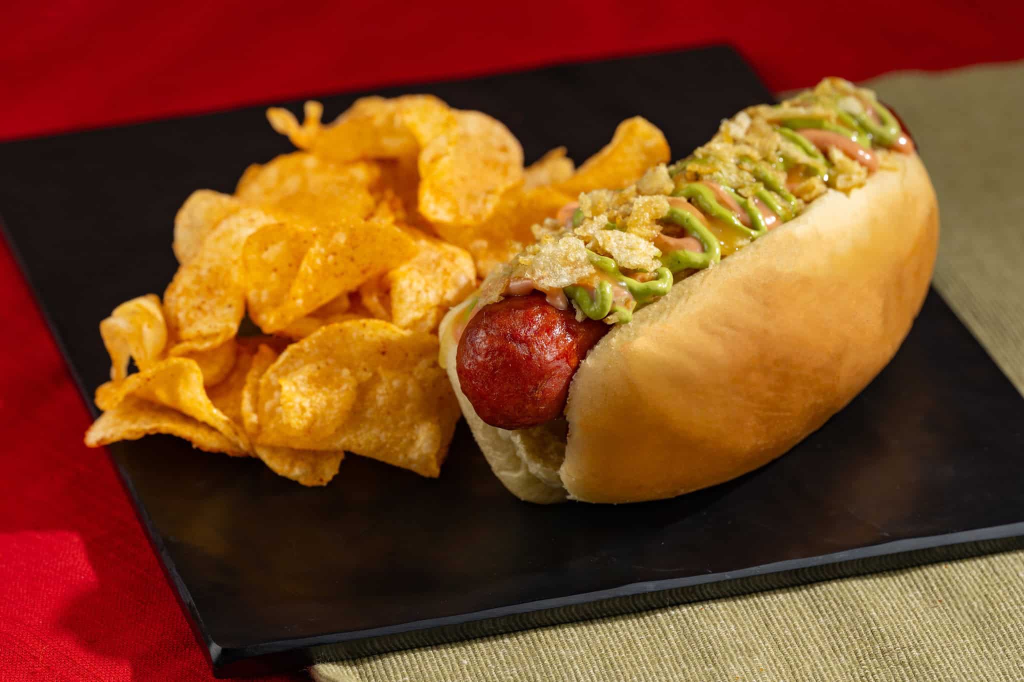 a hot dog on a plate with chips