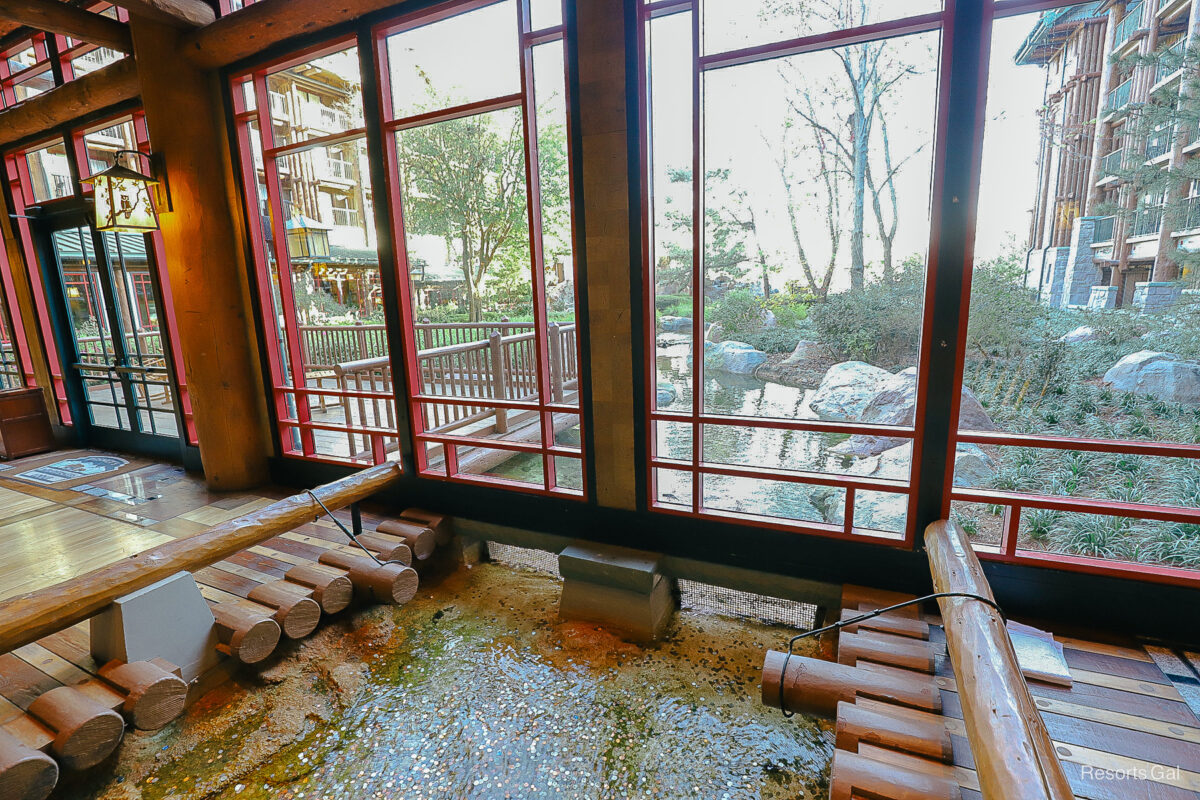water from the spring follows a path outside from an open area under a window