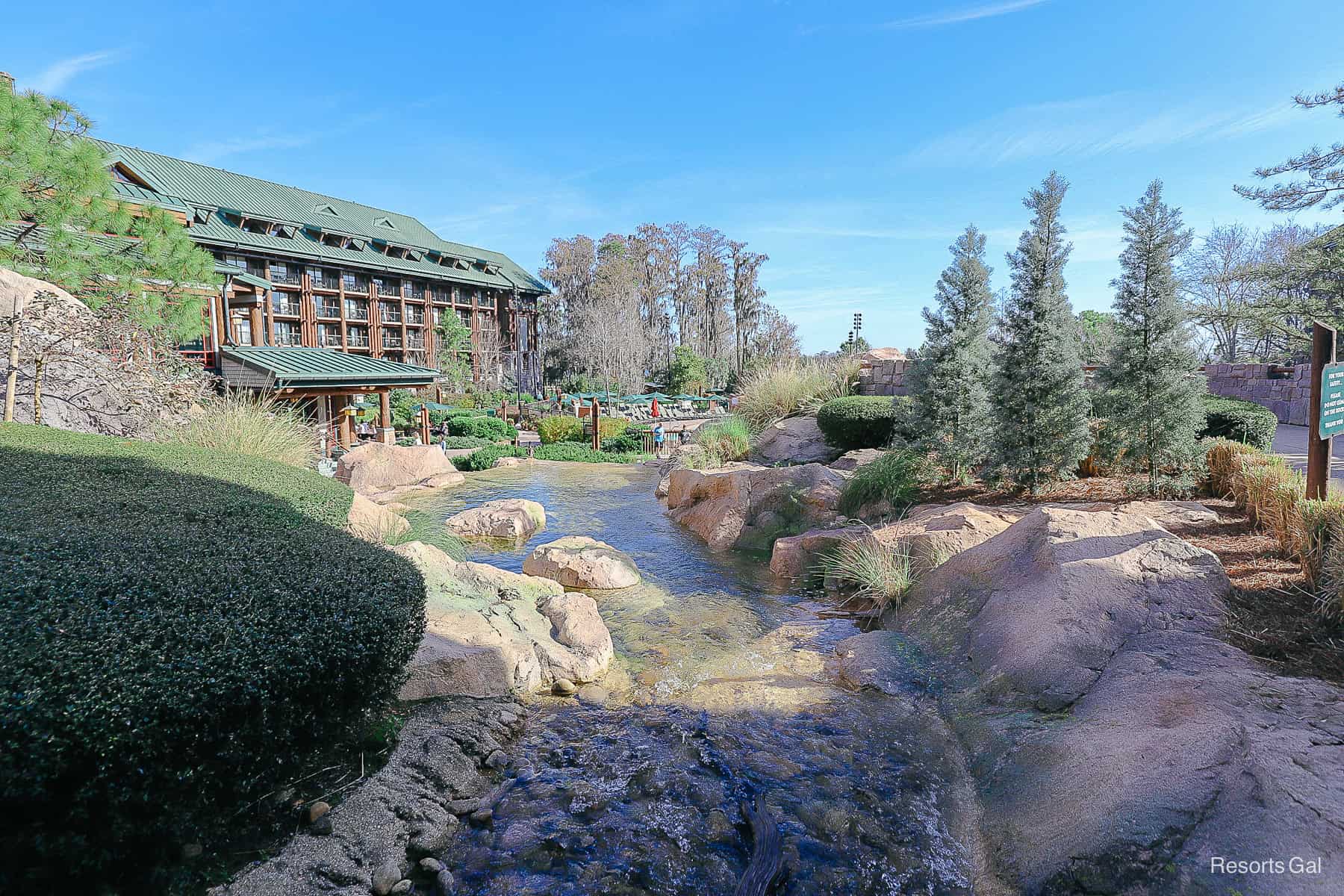 a stream or creek that leads to a waterfall with blue skies background 