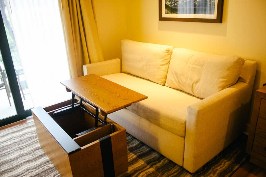 a table in front of a sofa that lifts to make the top come to your lap for dining or work in a room at Copper Creek Villas 