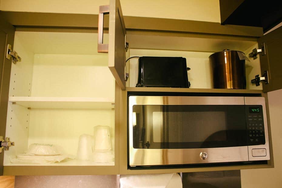 a closeup of the cabinets in the kitchenette with a toaster oven and ice bucket 
