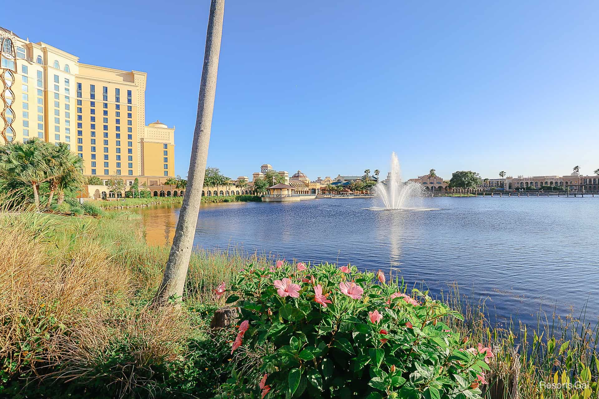 a fountain springs from the lake with pink hibiscus in bloom at Coronado Spring 