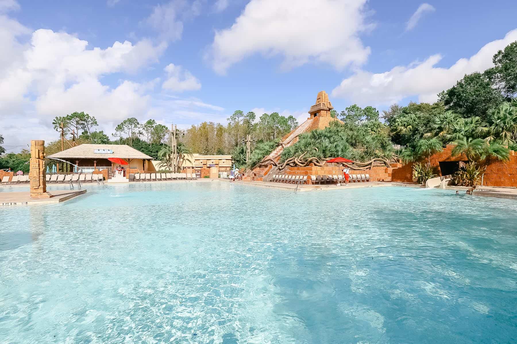 The large pool area with blue waters and a faux pyramid in the background. 