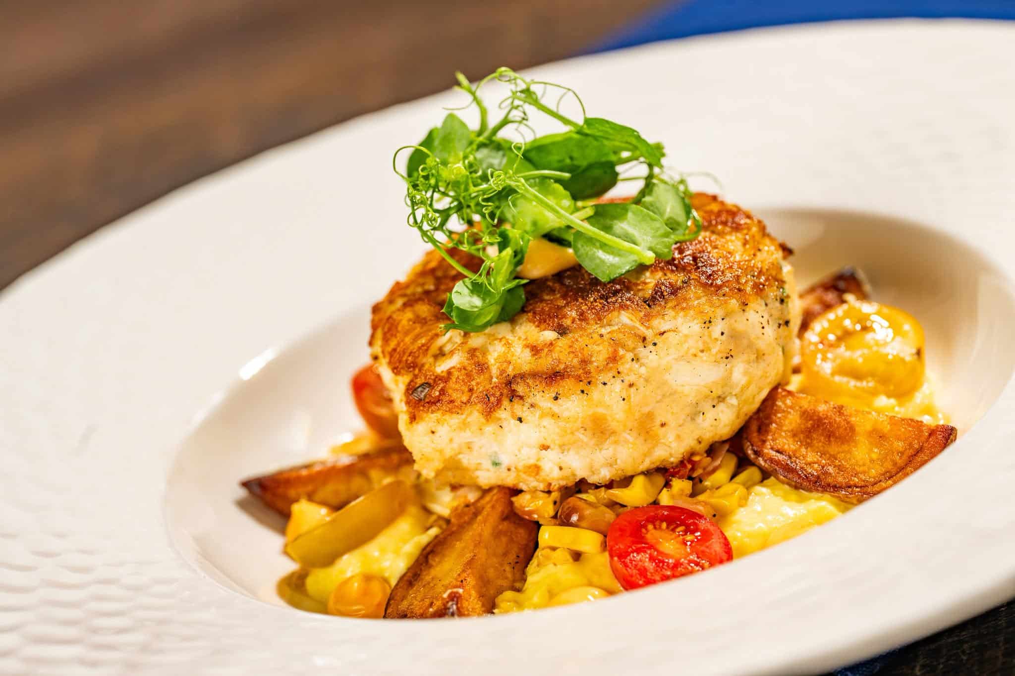 a crab cake topped with garnish